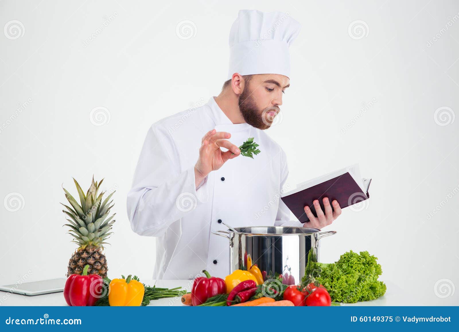 Male Chef Cook Reading Recipe Book while Preparing Food Stock Image