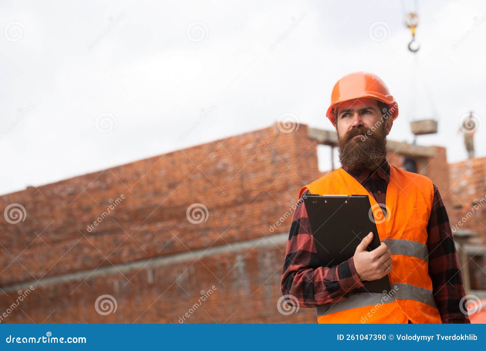 Male Construction Worker in Work Clothes and a Construction Helmet