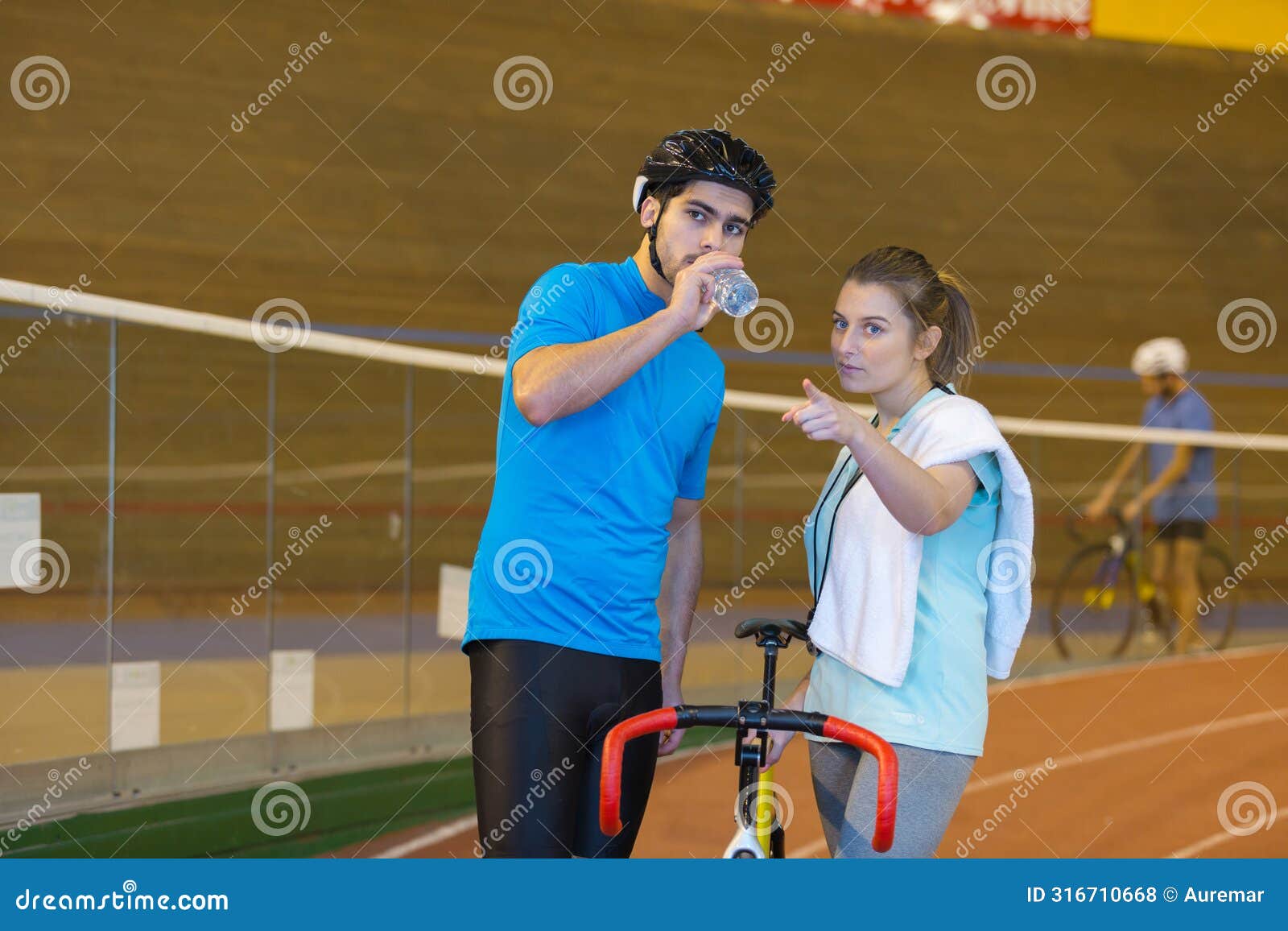 male cyclist holding bottled water in velodrome