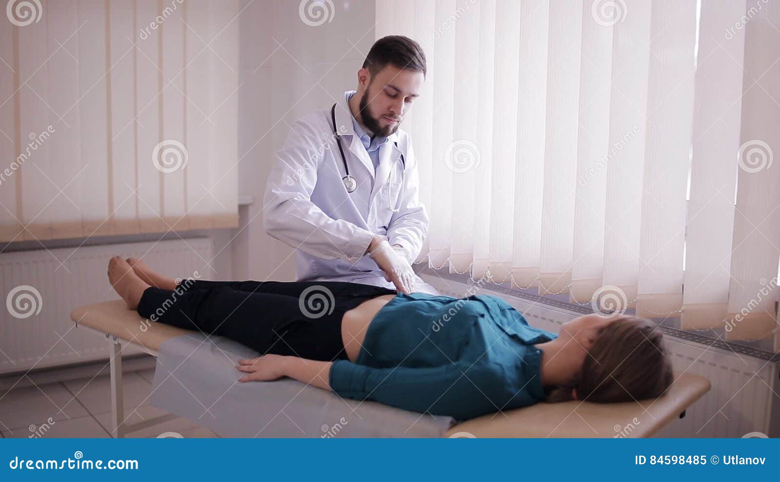 Male Doctor Makes Palpation Of The Abdomen Of The Patient The Girl