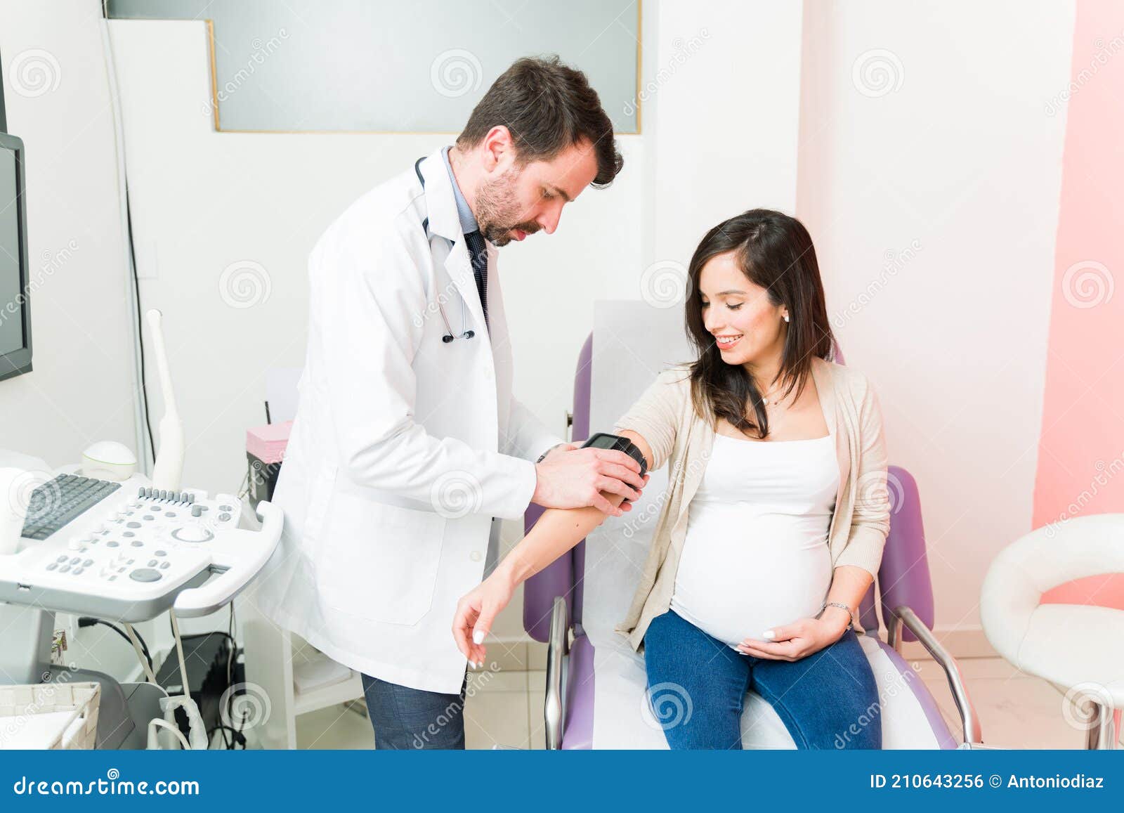 Handsome Gynecologist Doing a Medical Checkup on an Expectant Mother Stock Photo image