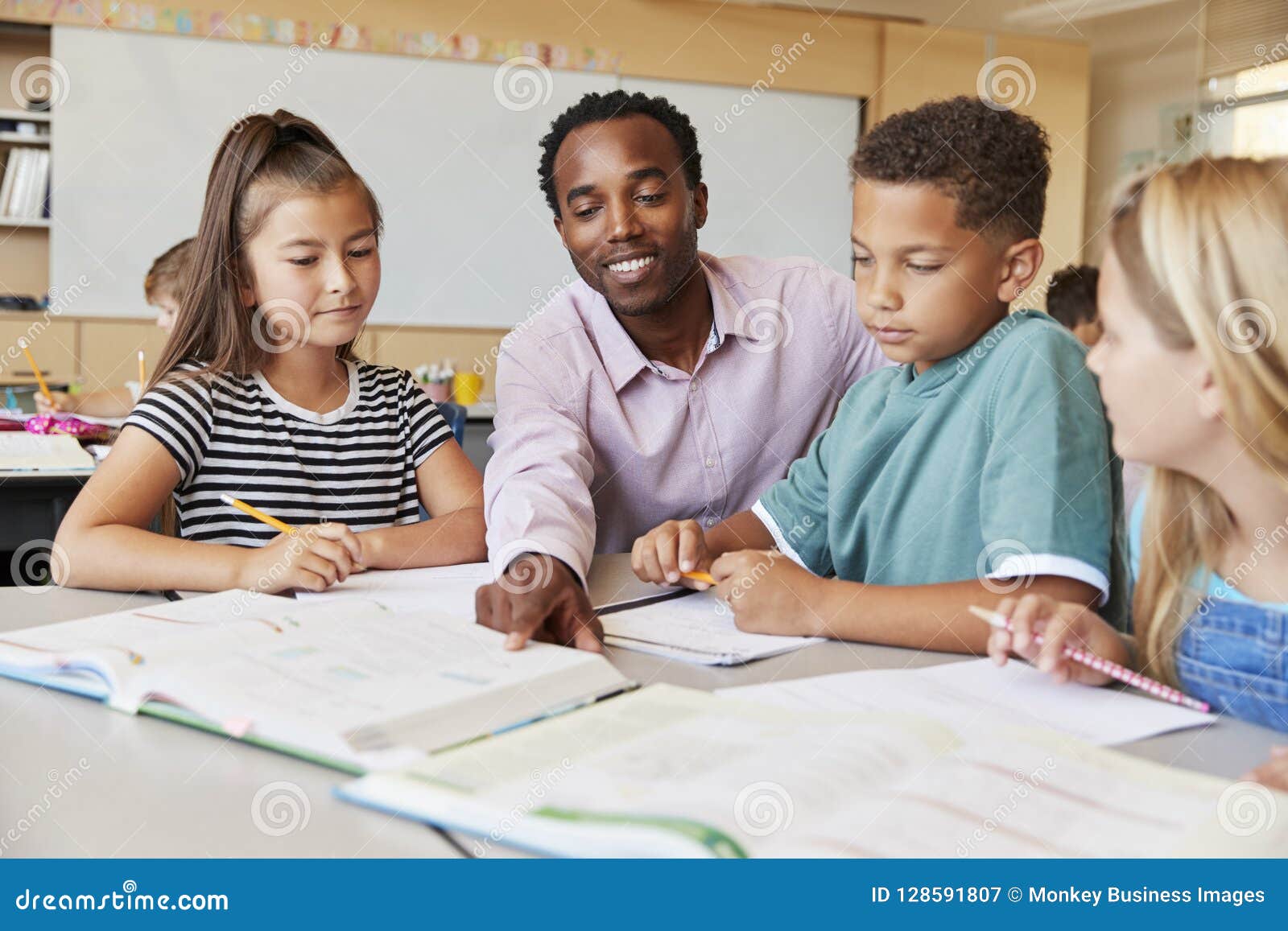 Male Elementary School Teacher Working in Class with Kids Stock Image