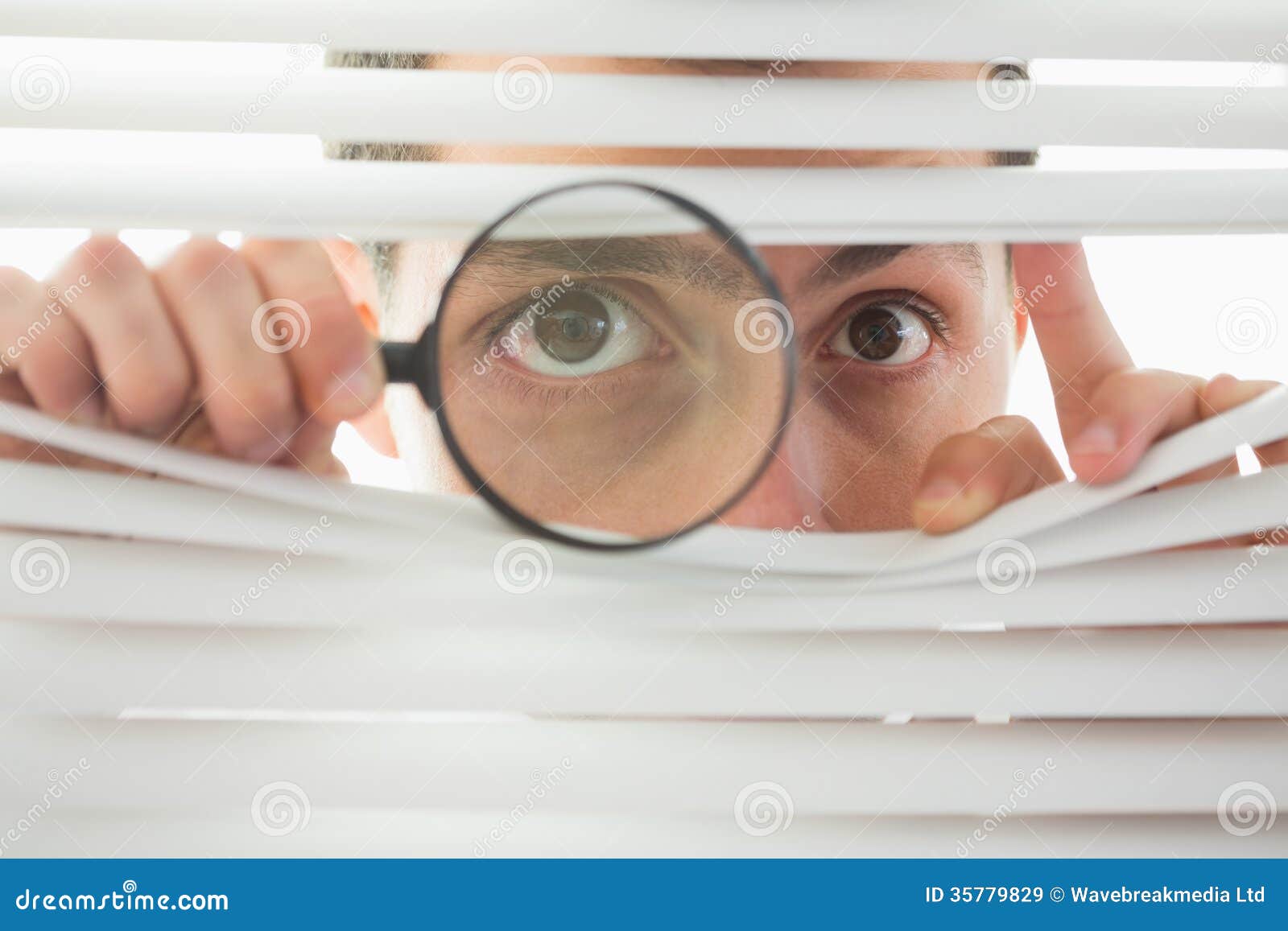 male eyes spying through roller blind with loupe