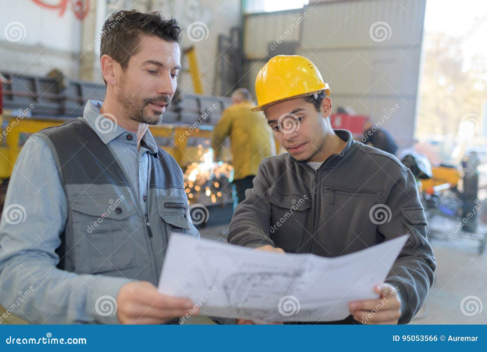 male factory worker and supervisor analyzing plans