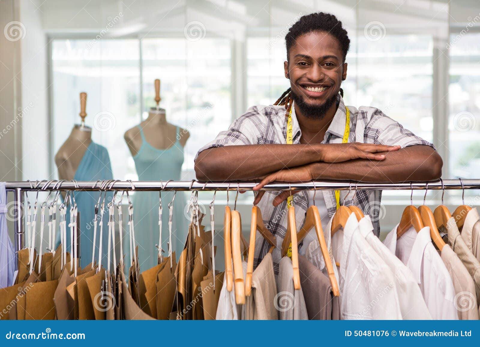 Male Fashion Designer Leaning on Rack of Clothes Stock Photo - Image of ...