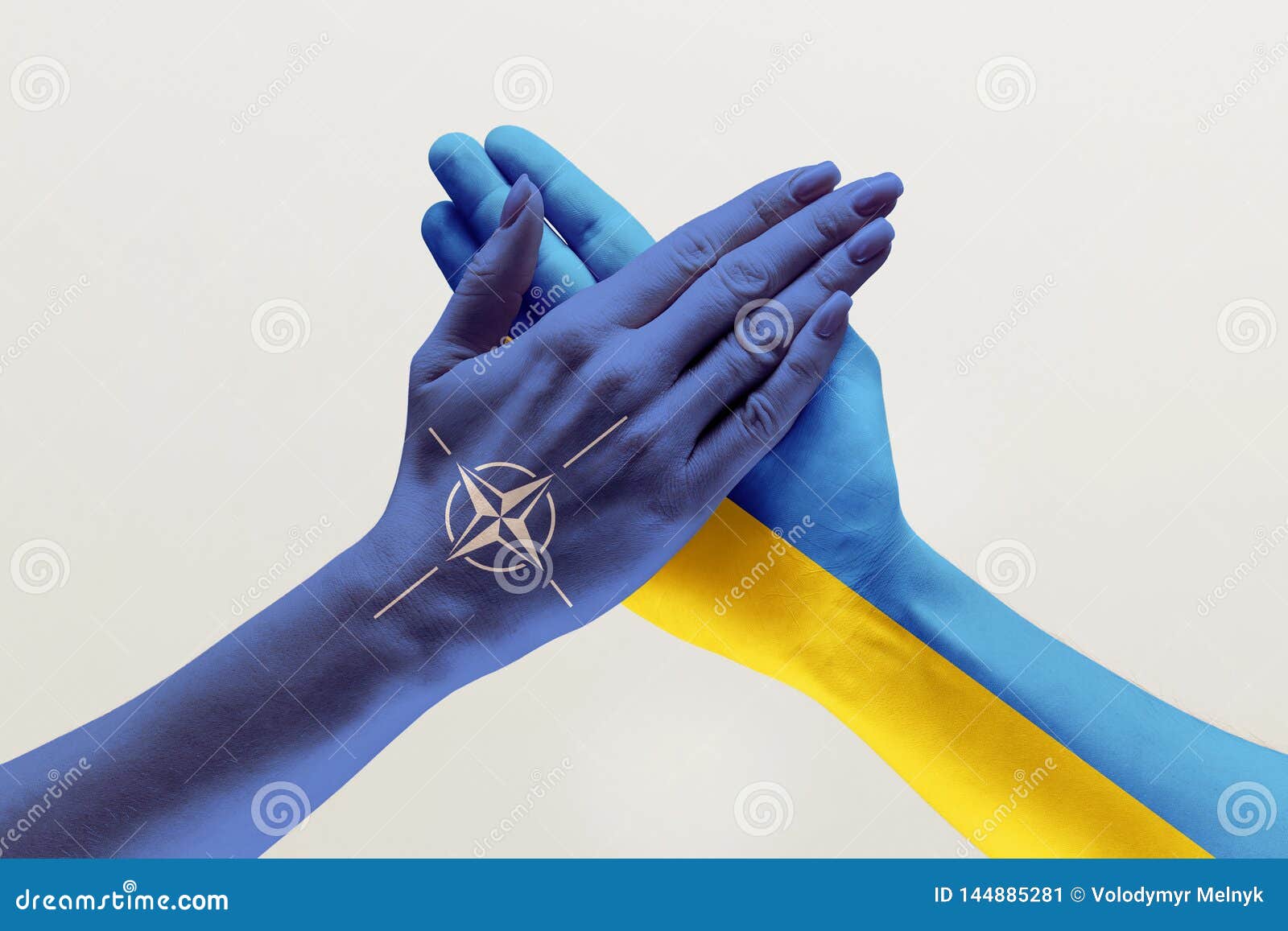 male and female hands colored in flags of ukraine and nato
