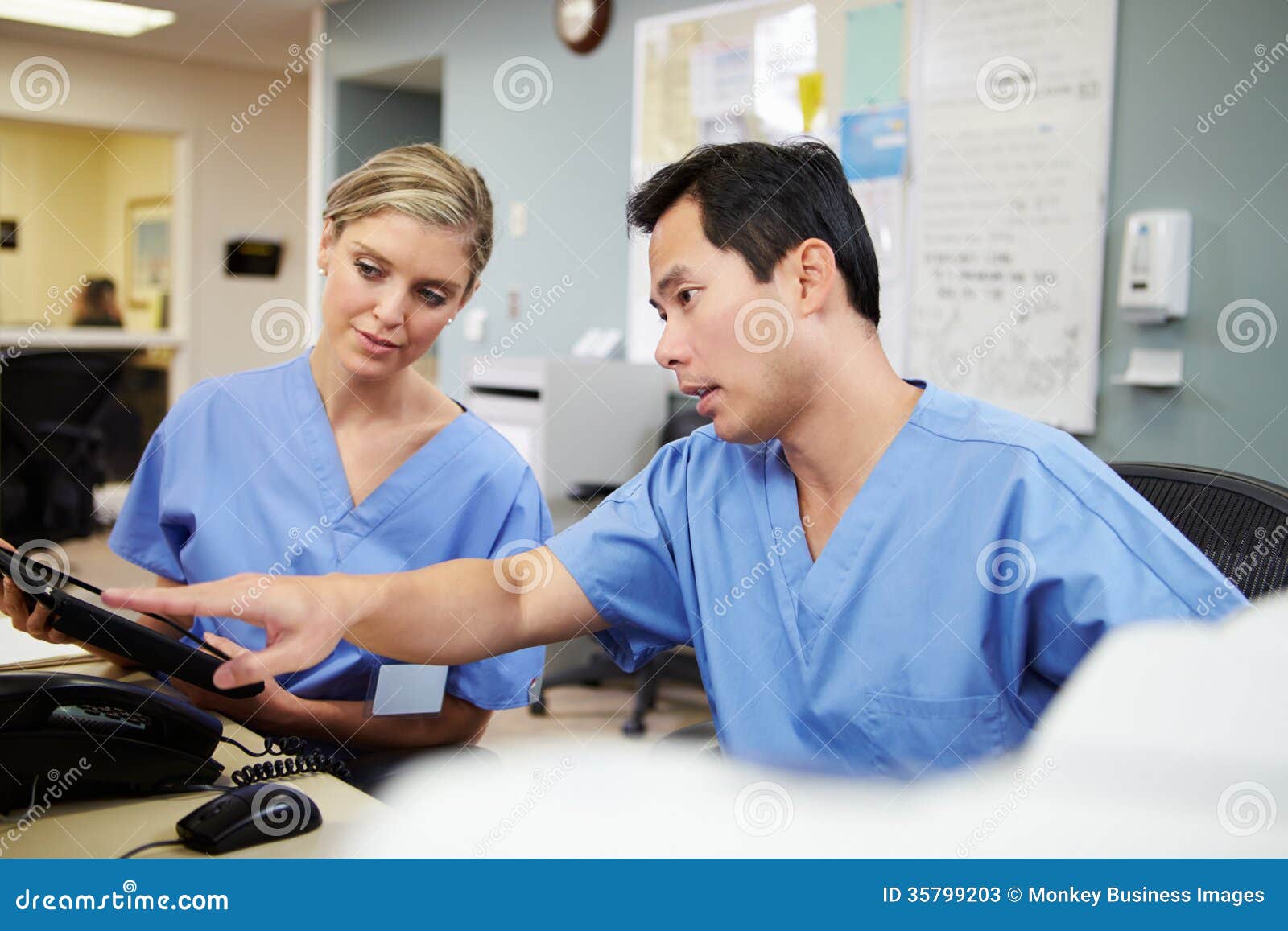 male and female nurse working at nurses station