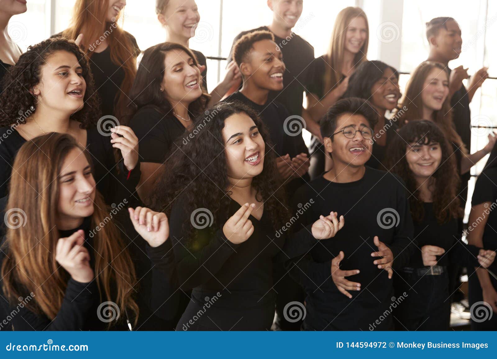 male and female students singing in choir at performing arts school