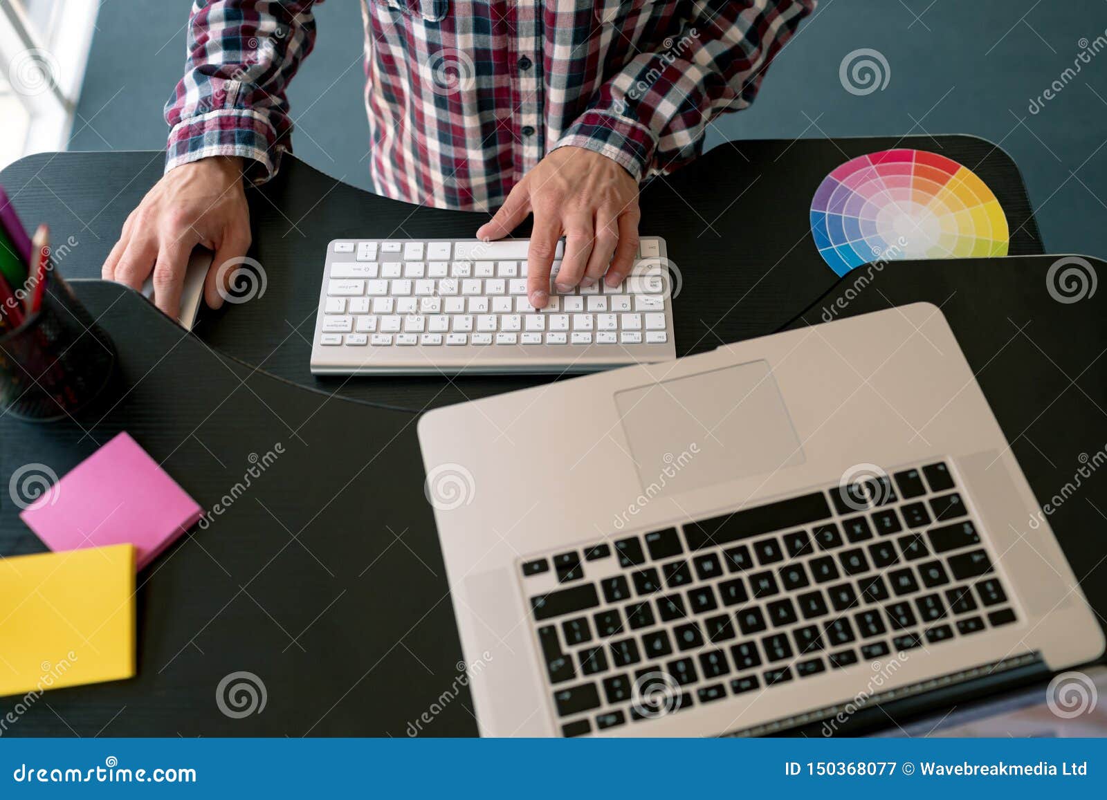Male Graphic Designer Working On Laptop At Desk In Office Stock