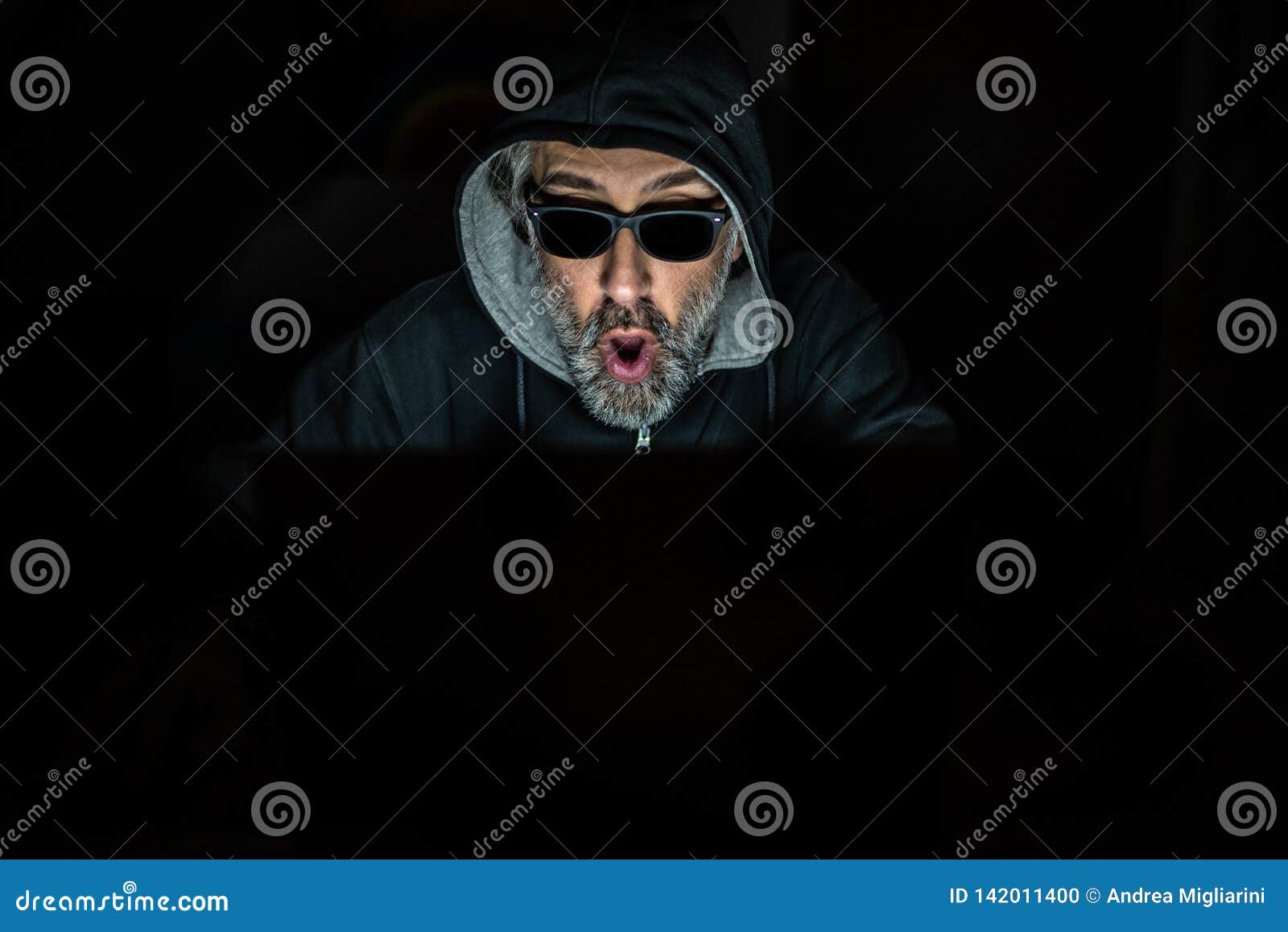 Male Hacker with Beard and Sunglasses Working on His Laptop, Amazed and