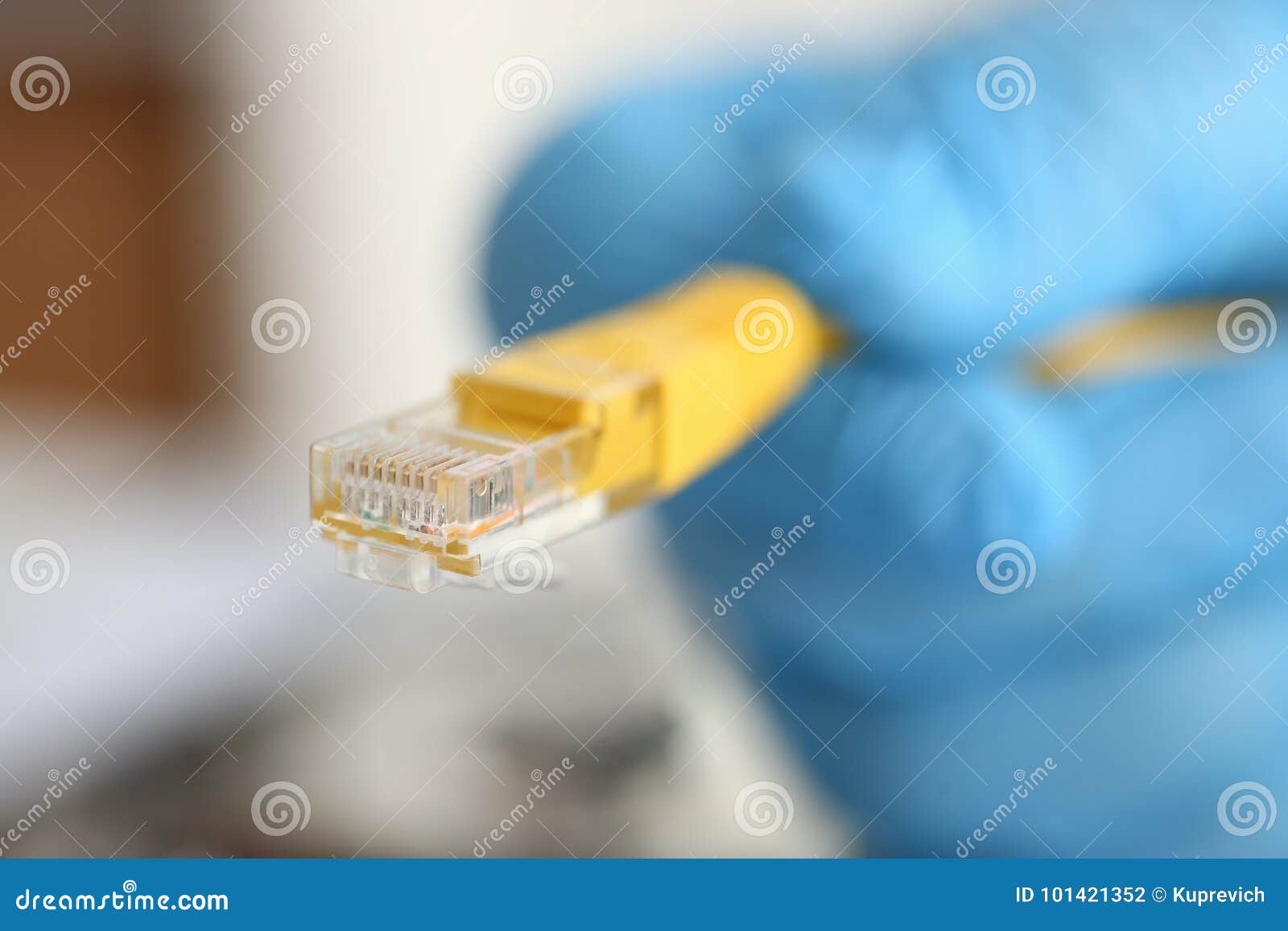 male hand in blue protective gloves holds a network connector