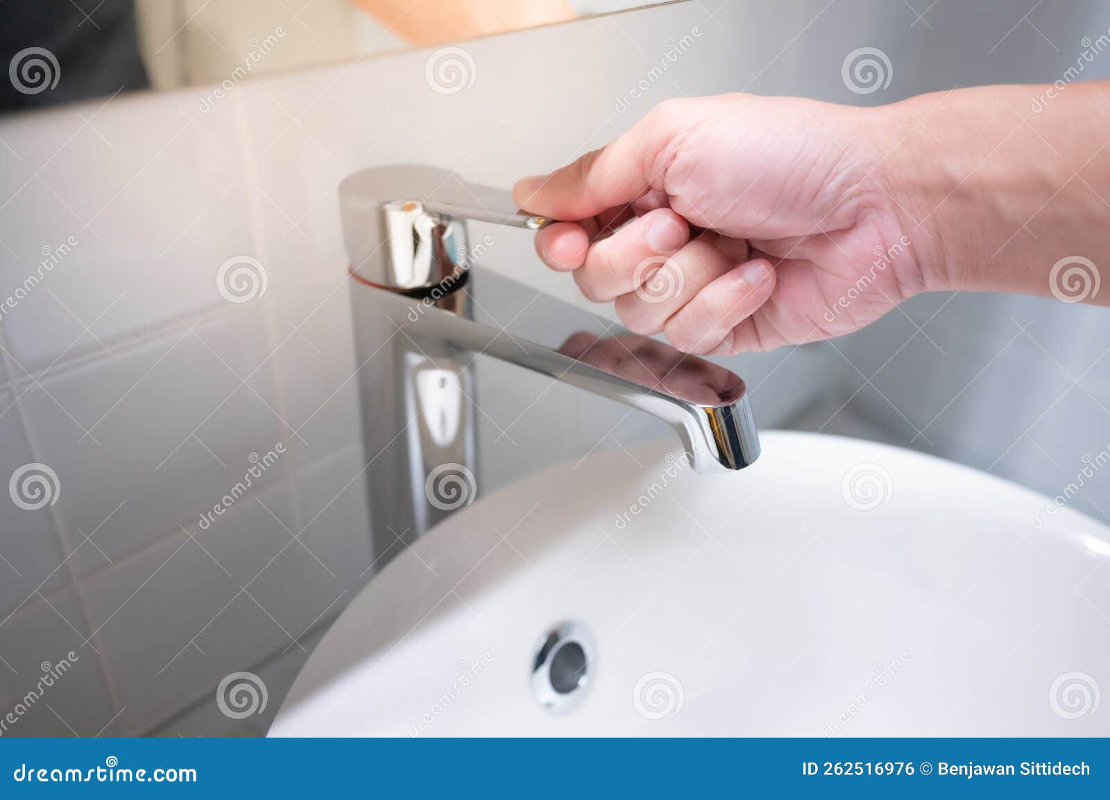 male hand closing water tap in bathroom