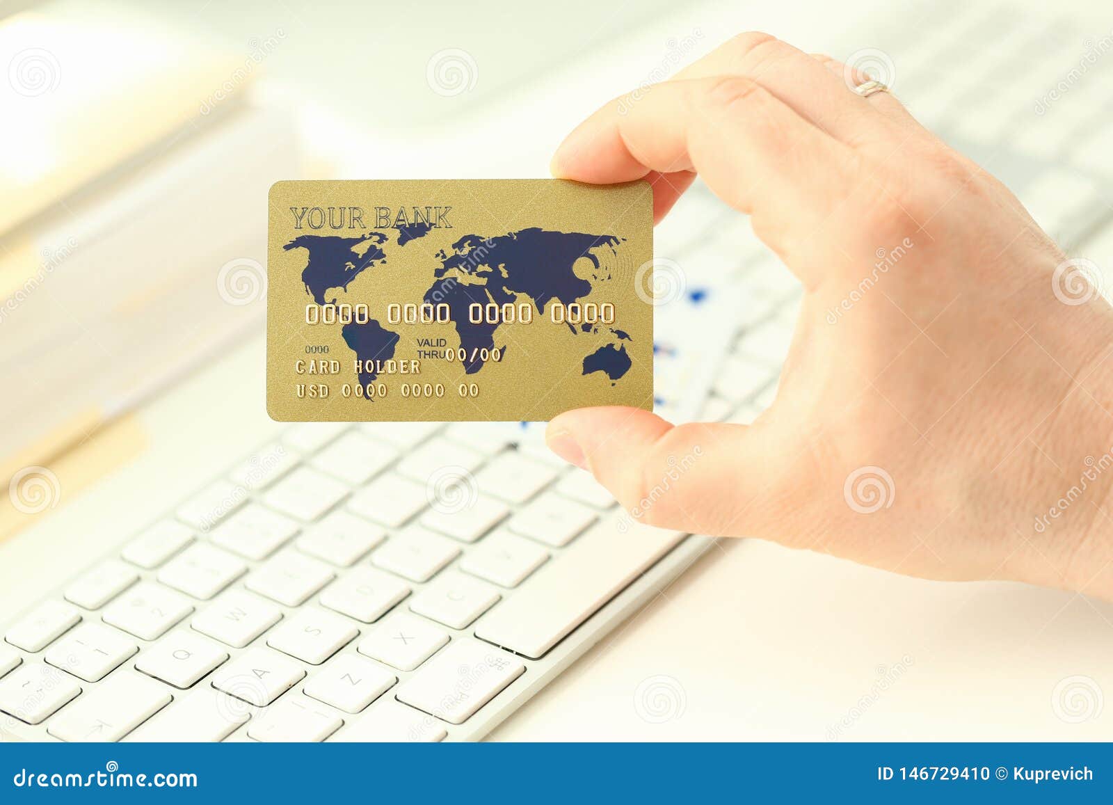 Male hand hold plastic bank card aganist keyboard background. Fast money transaction concept.