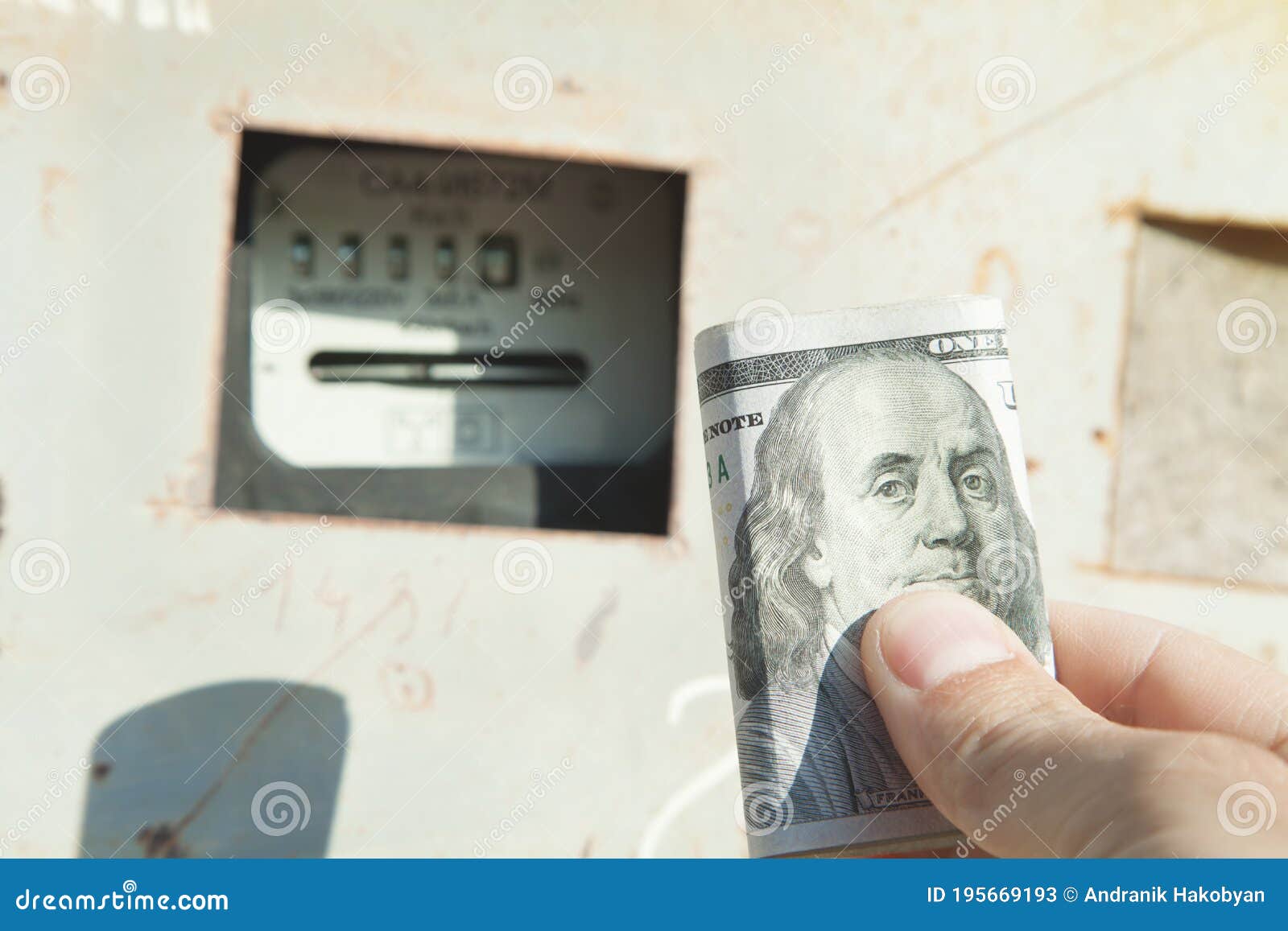 male hand holding dollar banknote. kilowatt hour electric meter. power
