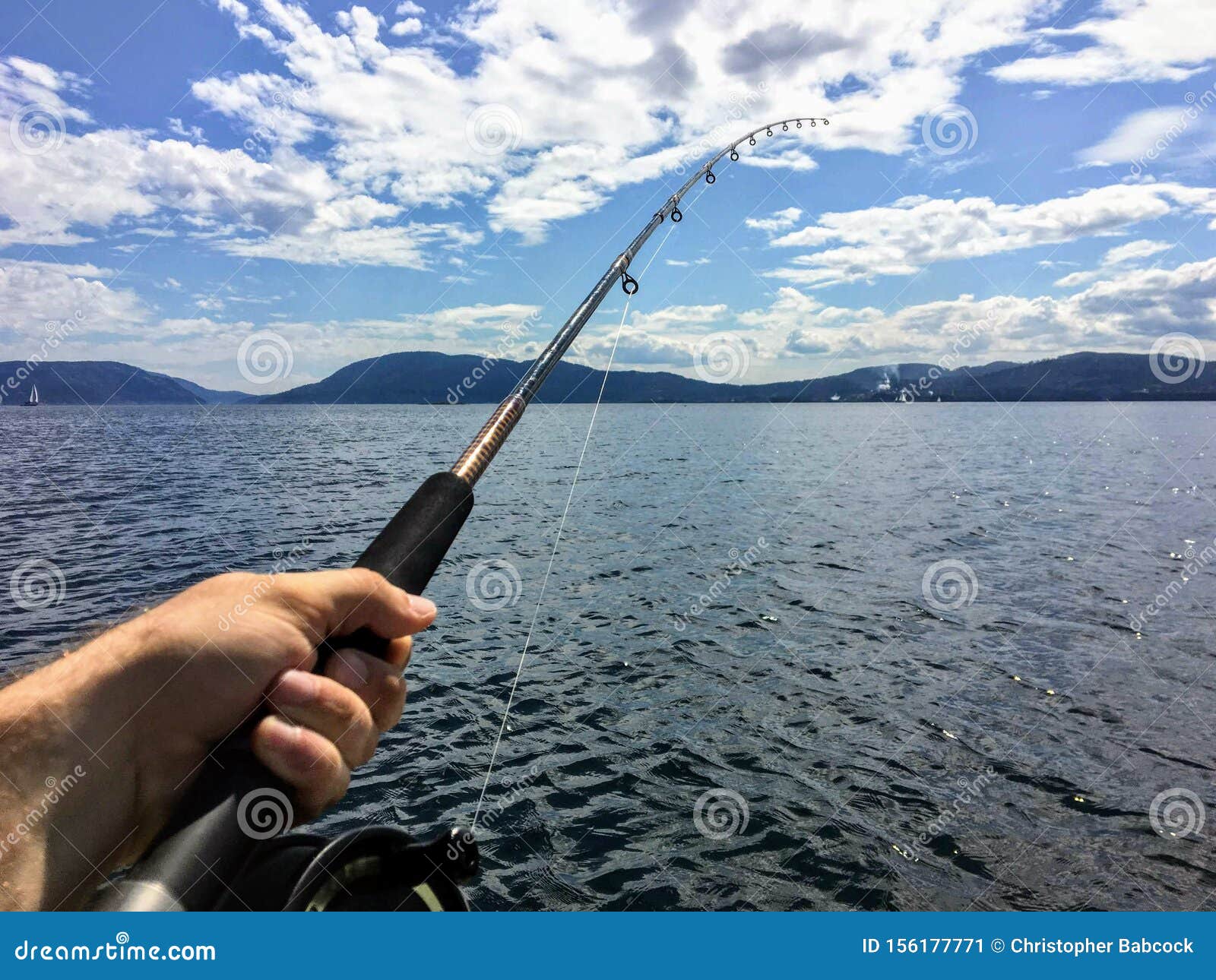 A Male Hand Holding a Fishing Rod Jigging for Fish with the Beautiful  Coastline of British Columbia Canada in the Background. Stock Image - Image  of jigging, open: 156177771