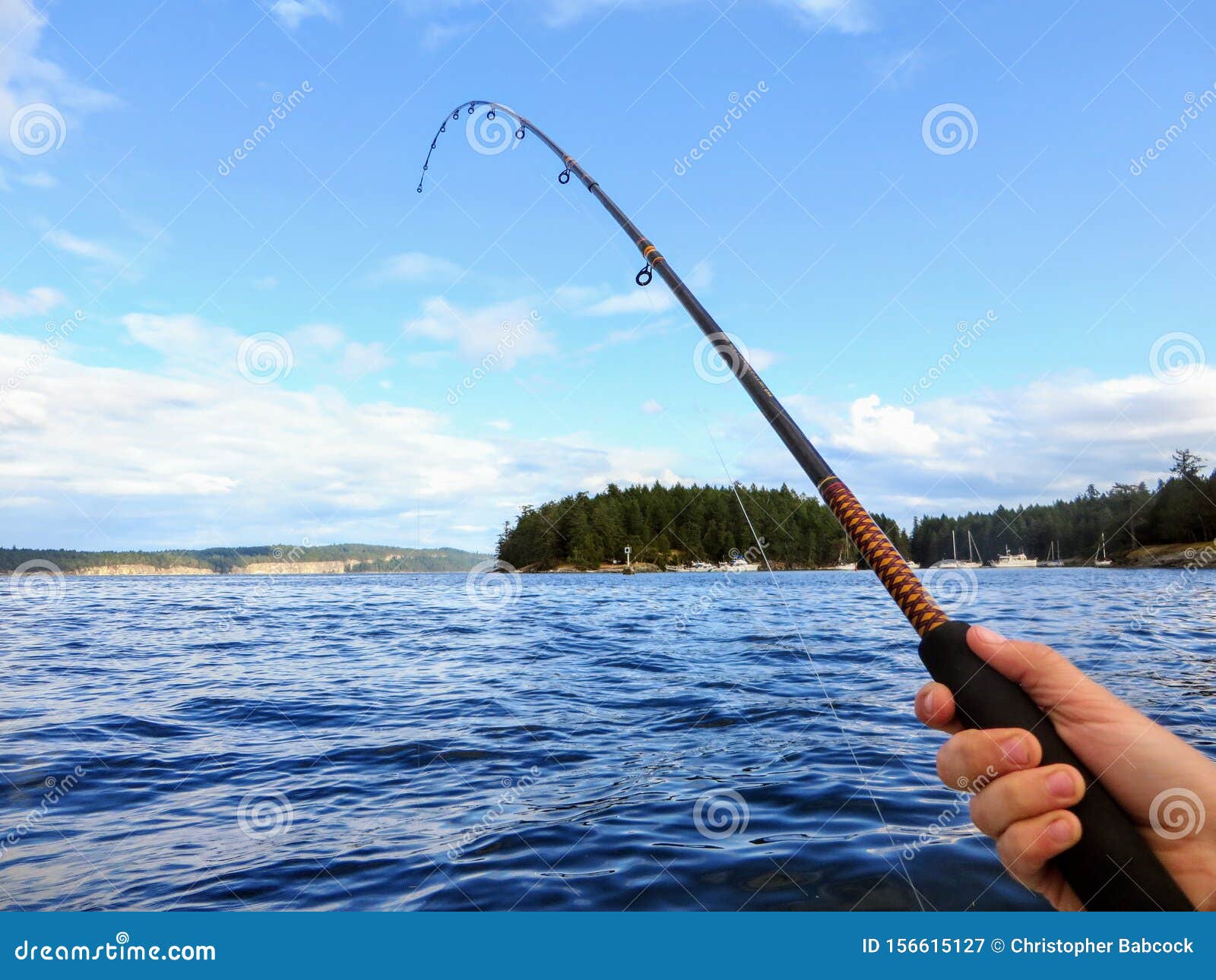 A Male Hand Holding a Fishing Rod Over the Ocean. the Rod is Pointing Right  and Upwards Towards the Sky. Room for Text. Stock Image - Image of room,  right: 156615127