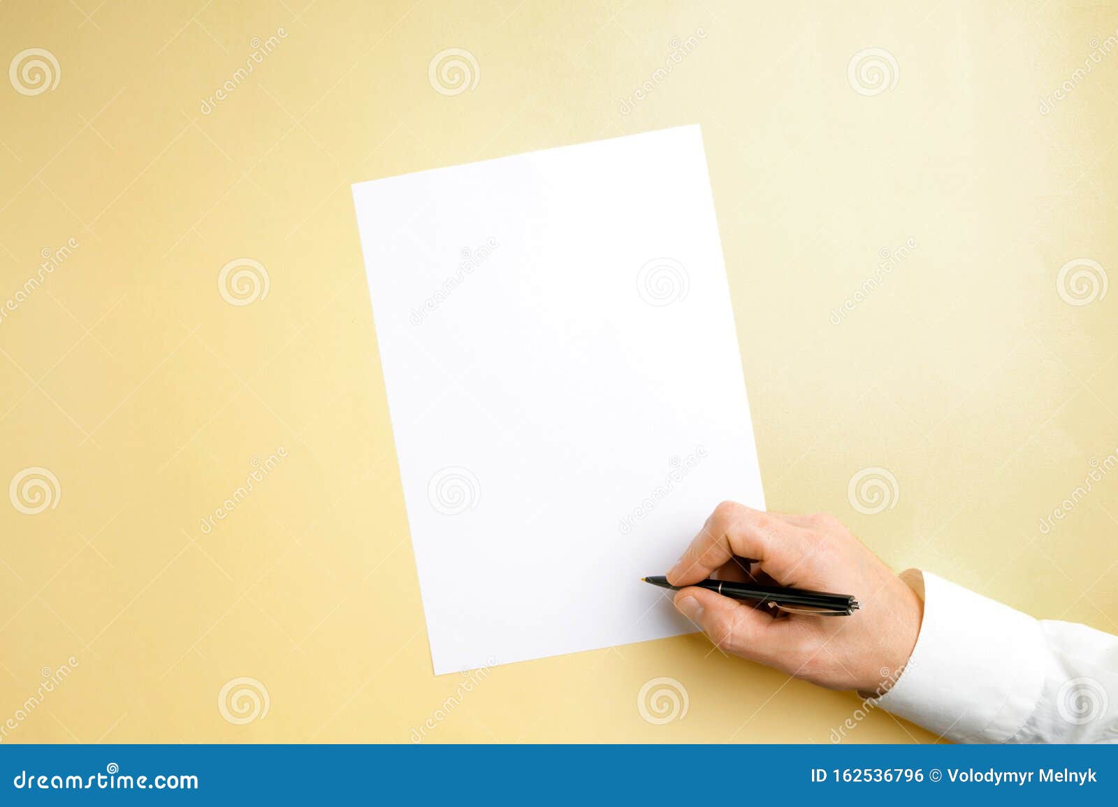 Male Hand Holding Pen and Writing on Empty Sheet on Yellow Background ...