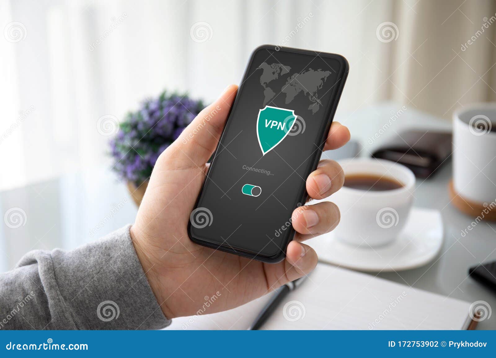 male hand holding phone with app vpn on the screen