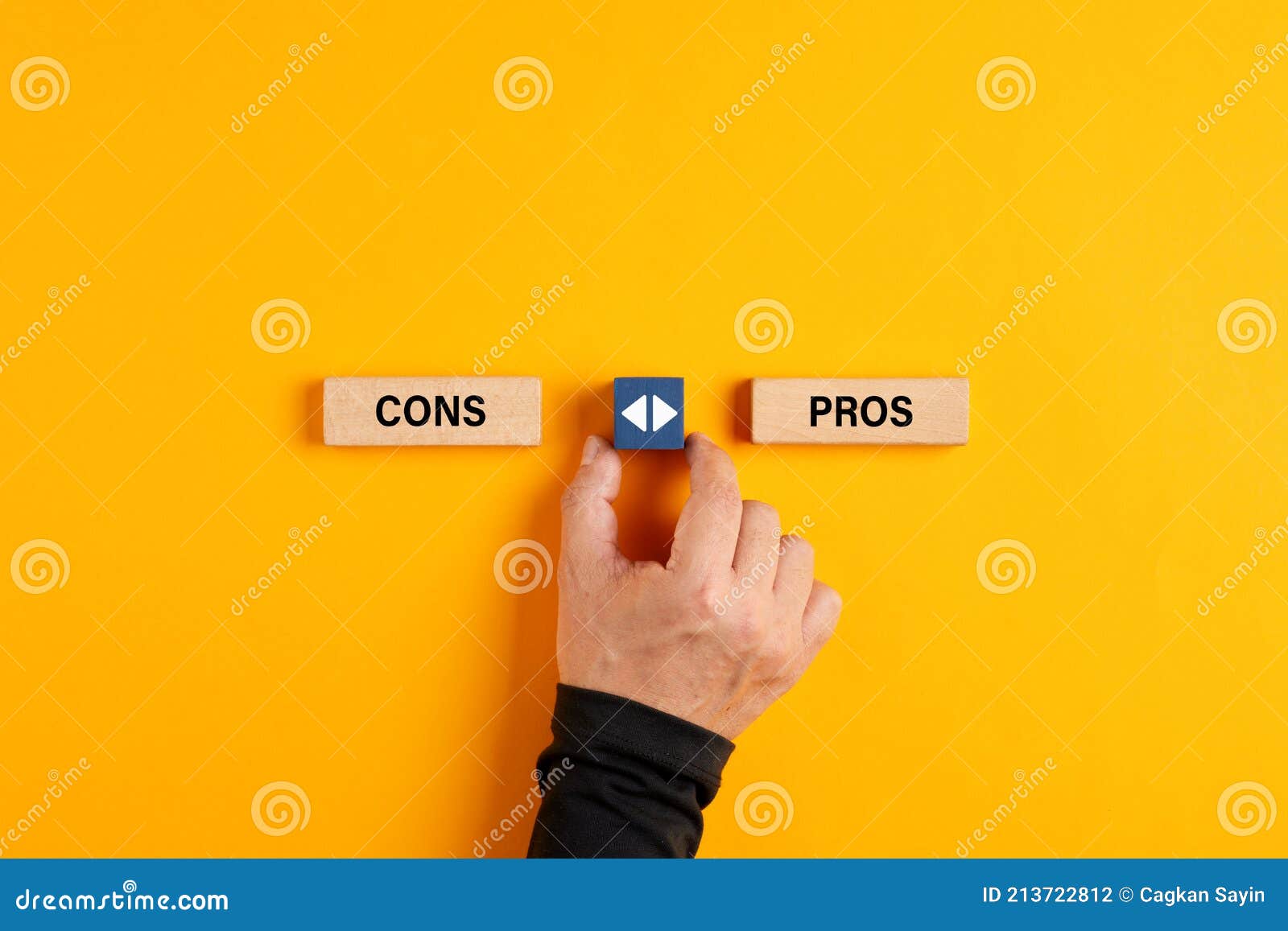 male hand holds a wooden cube with arrow icon is about to make a choice between pros and cons