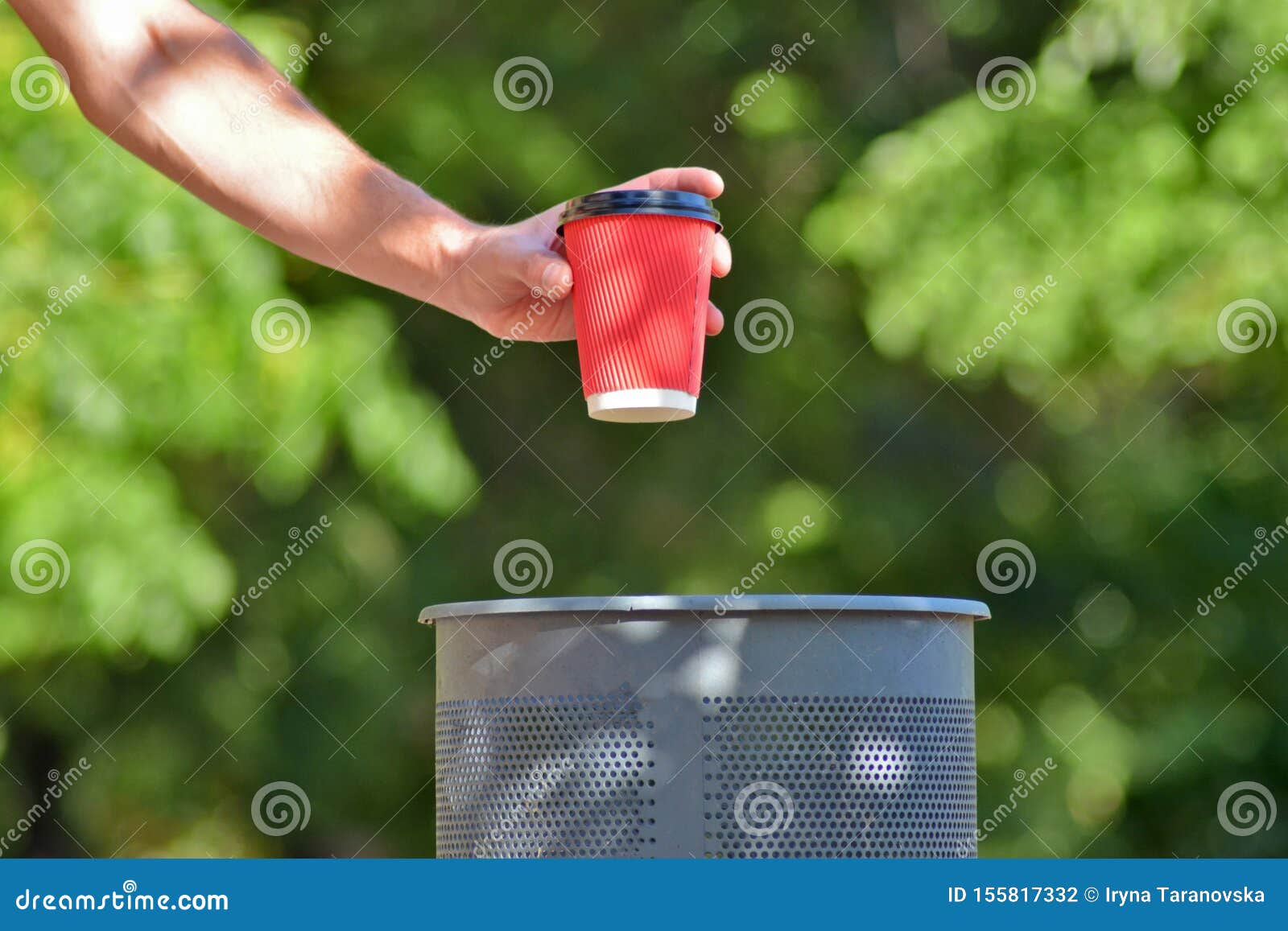 A Male Hand is Preparing To Throw Red Paper Cup for Coffee in a Trash Can  on a Background of Green Trees Stock Photo - Image of fast, ecological:  155817332