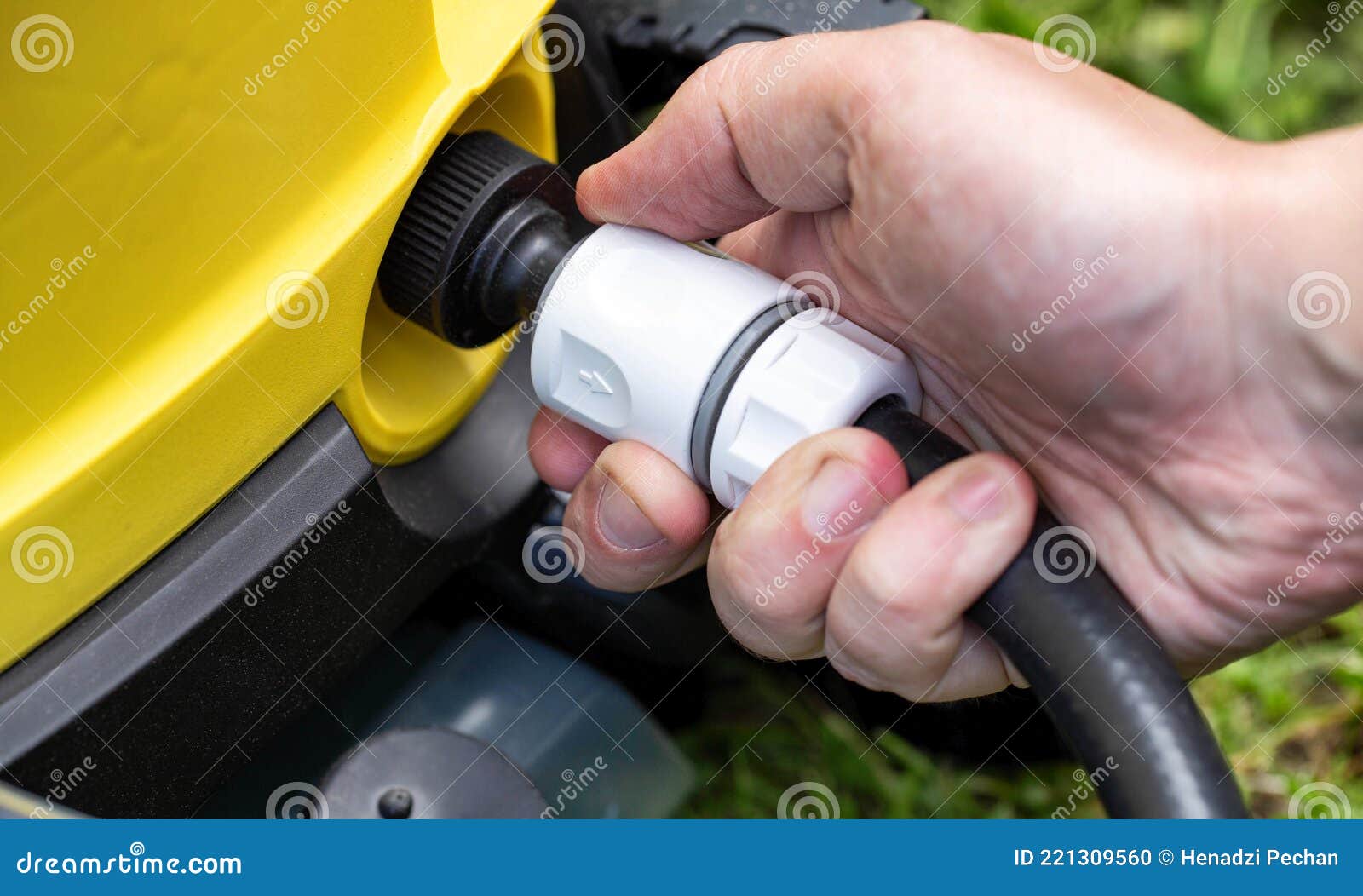 Male hand puts the quick-release hose coupling for water on the pressure washer, close-up. Industrial