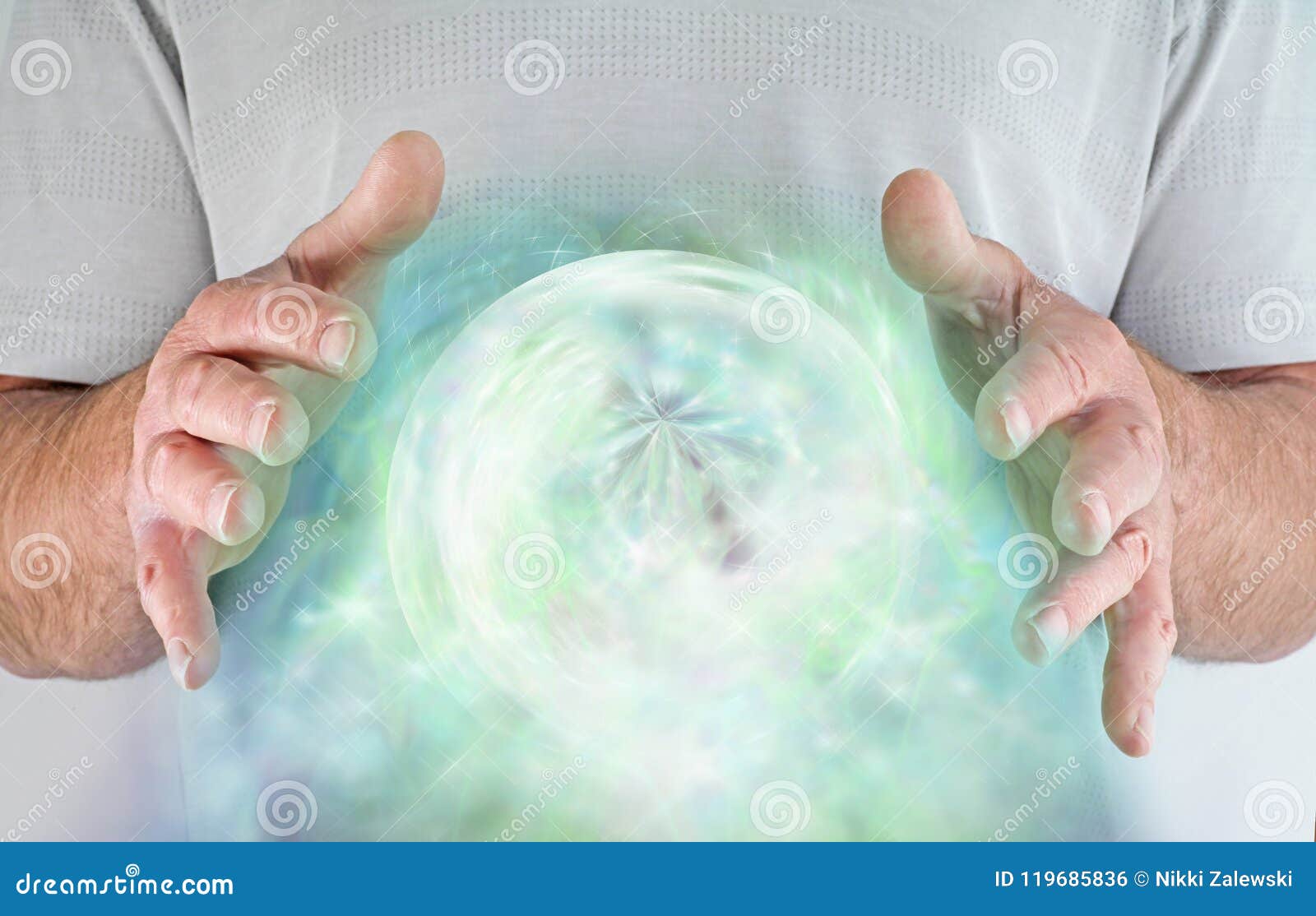 male with hands around a green heart chakra orb of energy