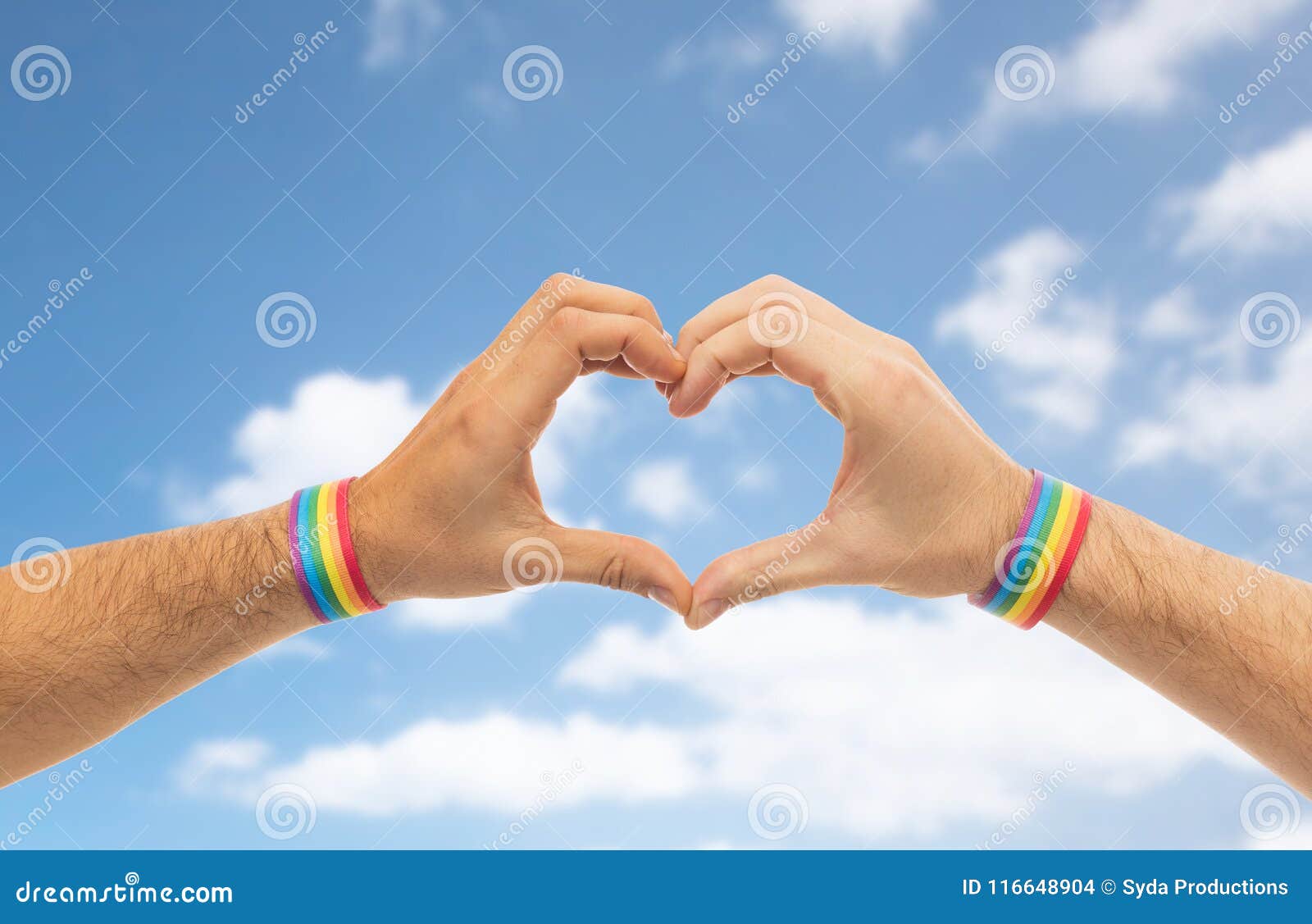 male hands with gay pride wristbands showing heart