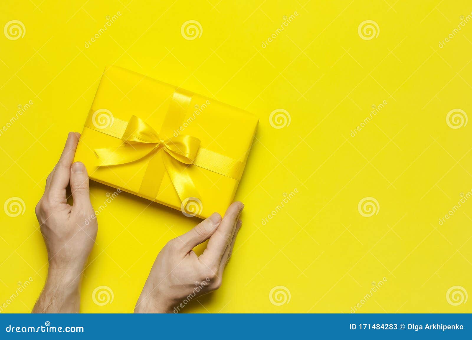 Male Hands Holding Bright Yellow Gift Present Box With