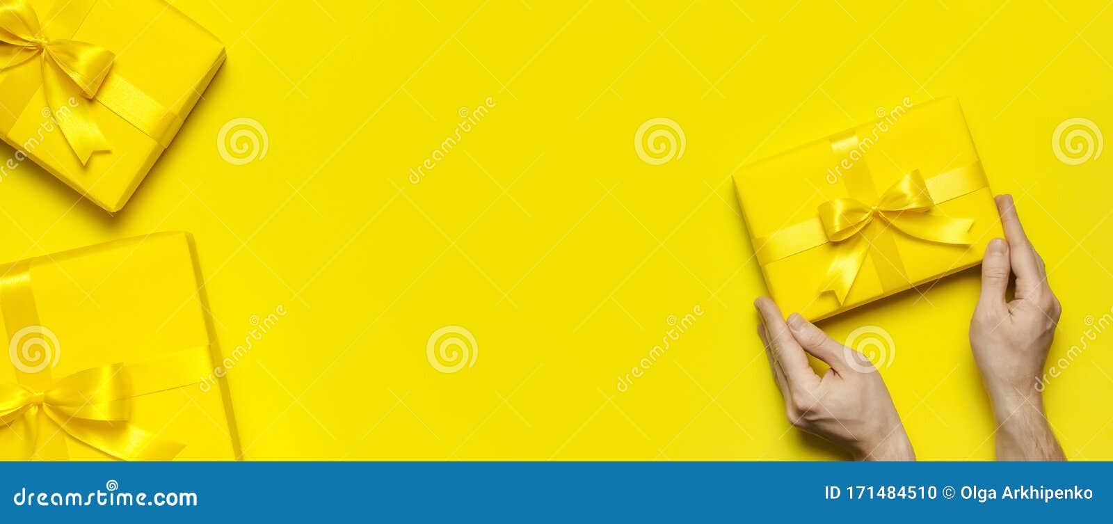 Male Hands Holding Bright Yellow Gift Present Box With