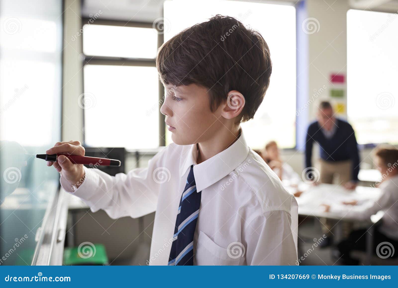 Male High School Student Wearing Uniform Using Interactive Whiteboard