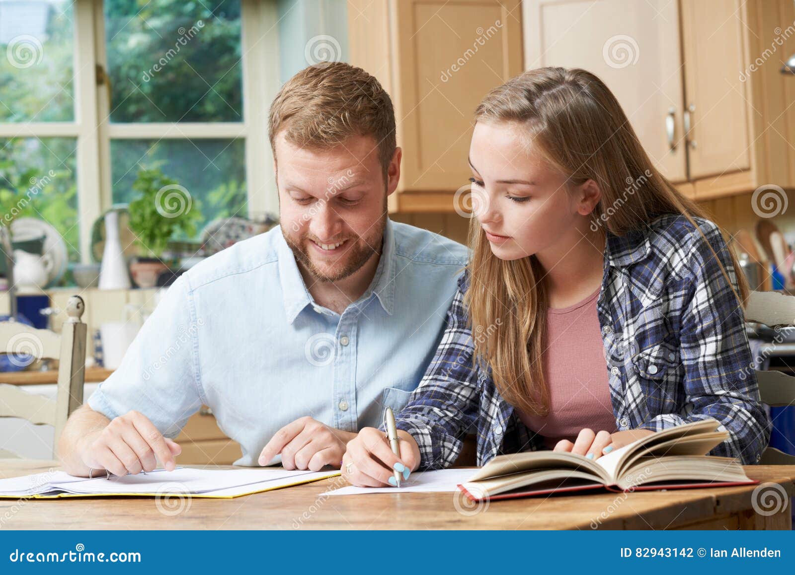 male home tutor helping teenage girl with studies
