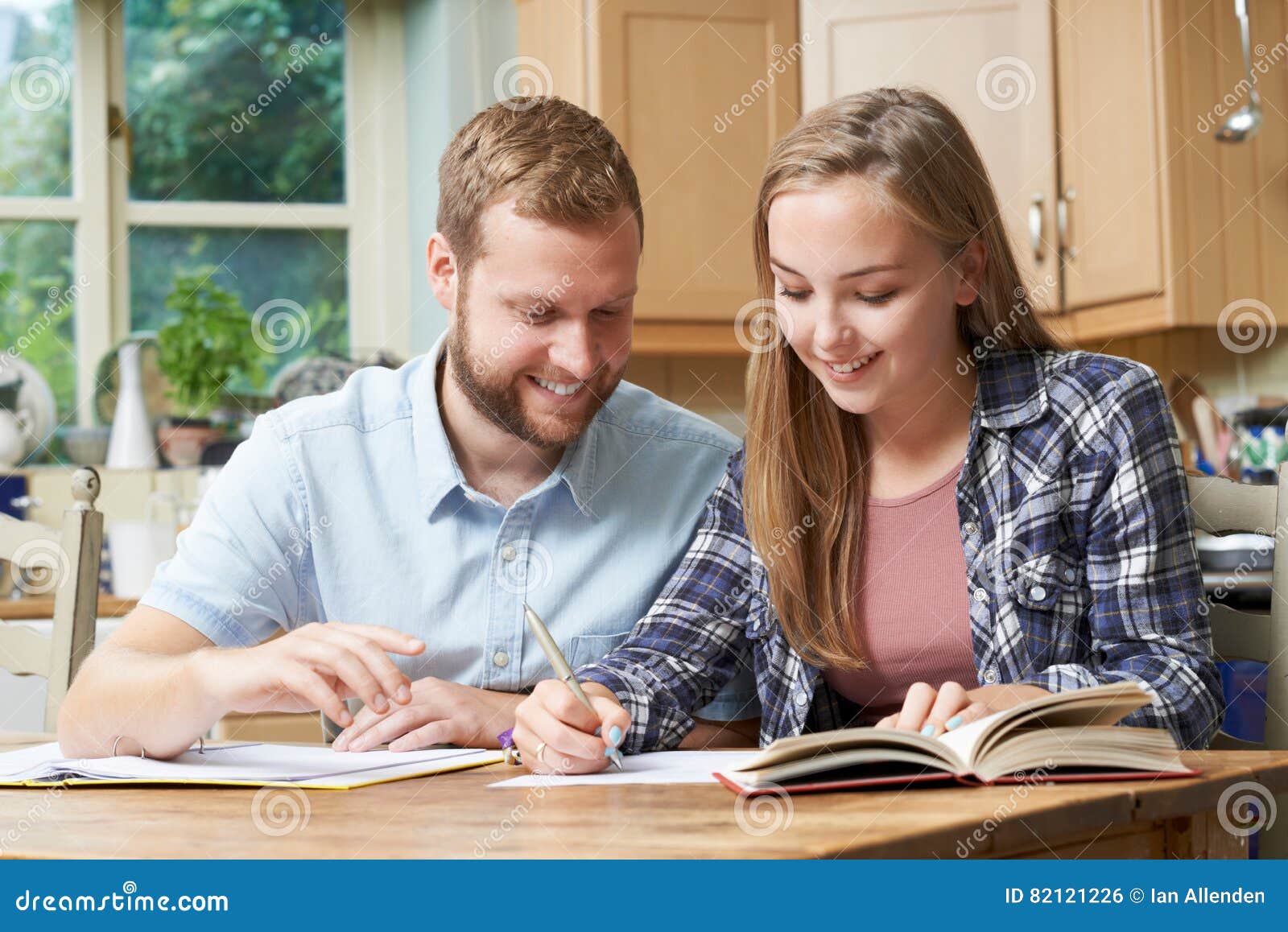 male home tutor helping teenage girl with studies