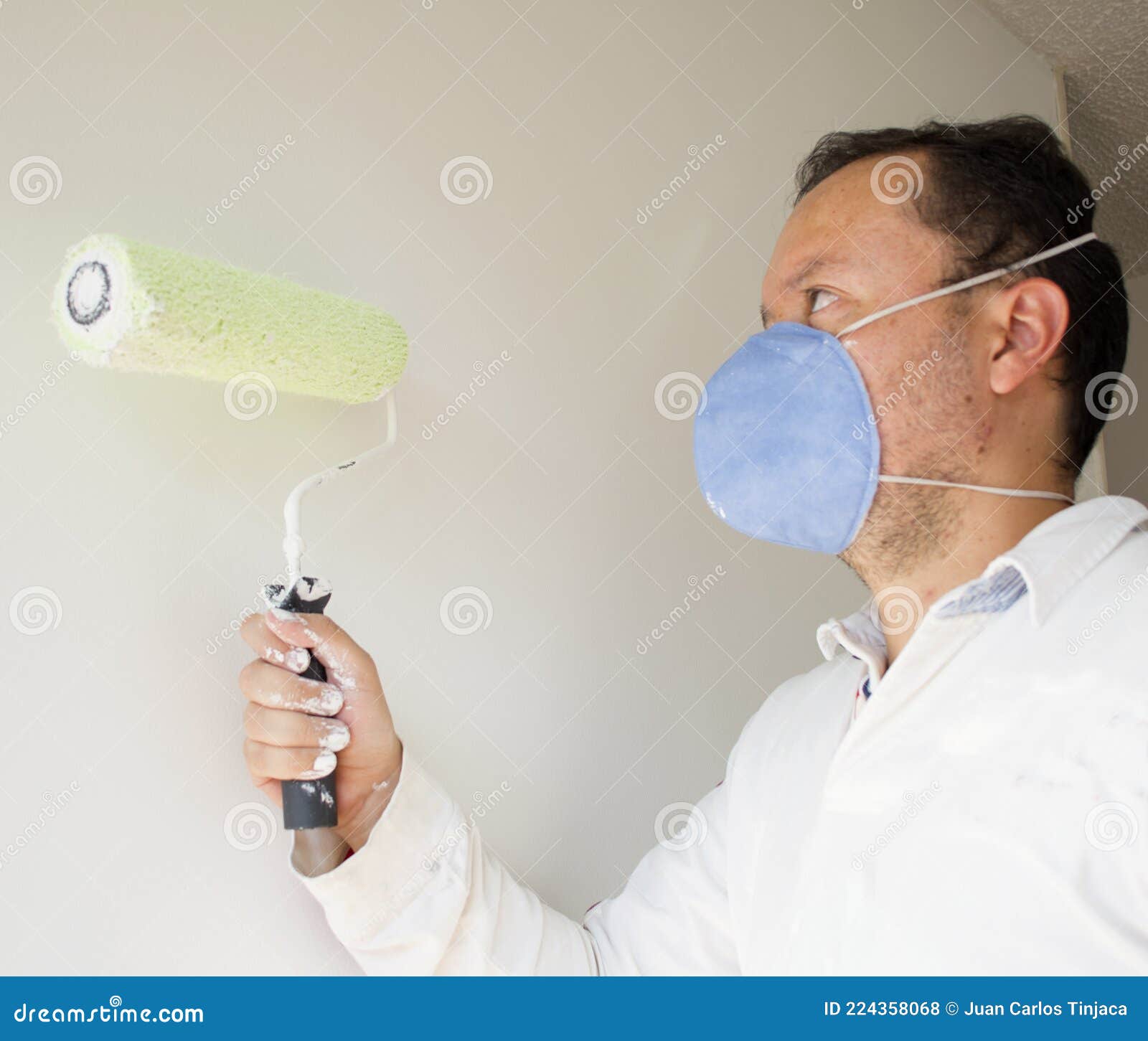 Male House Painter Worker Painting and Priming Wall with Painting