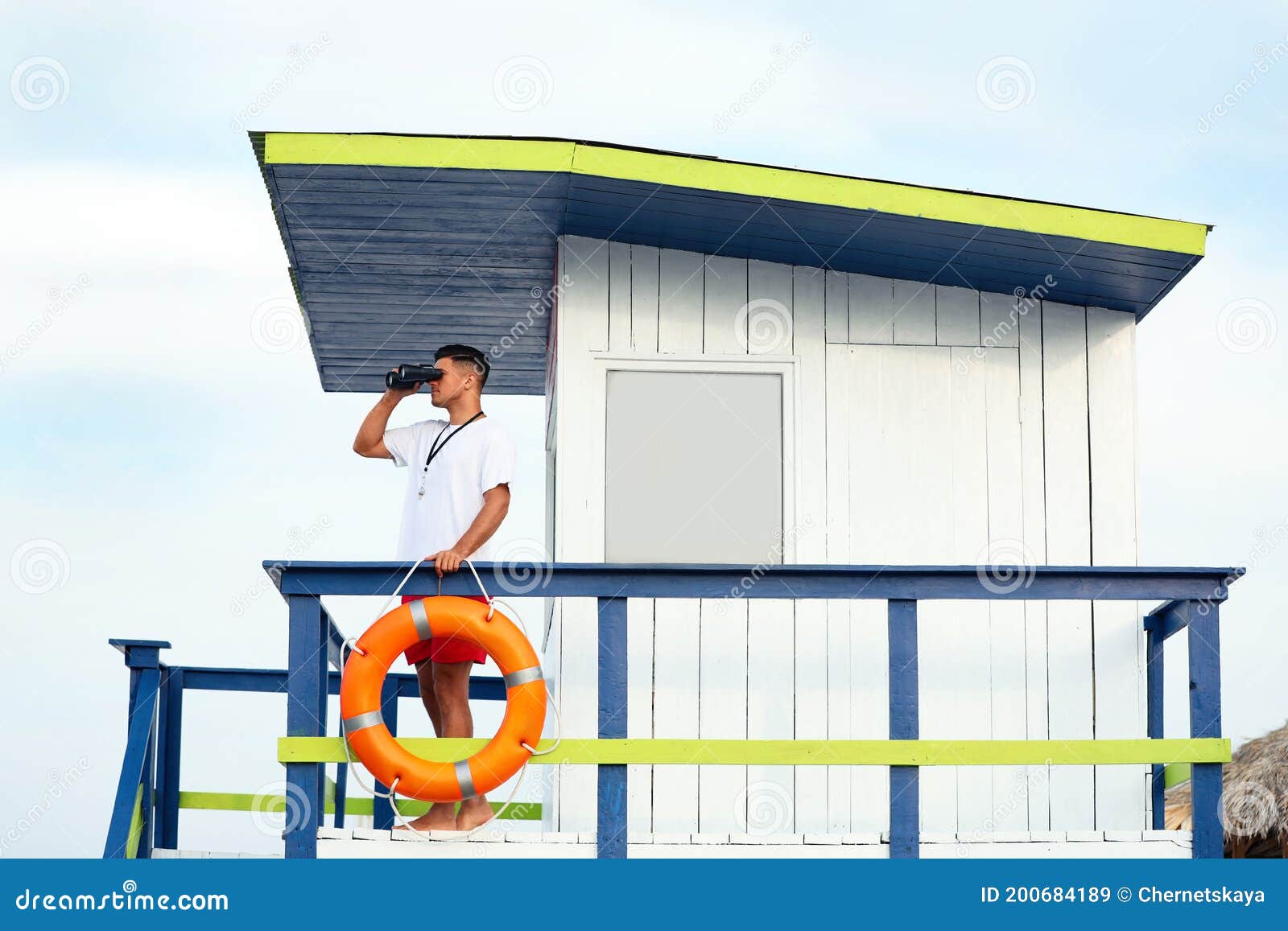 Male Lifeguard With Binocular On Watch Tower Against Blue Sky Stock ...