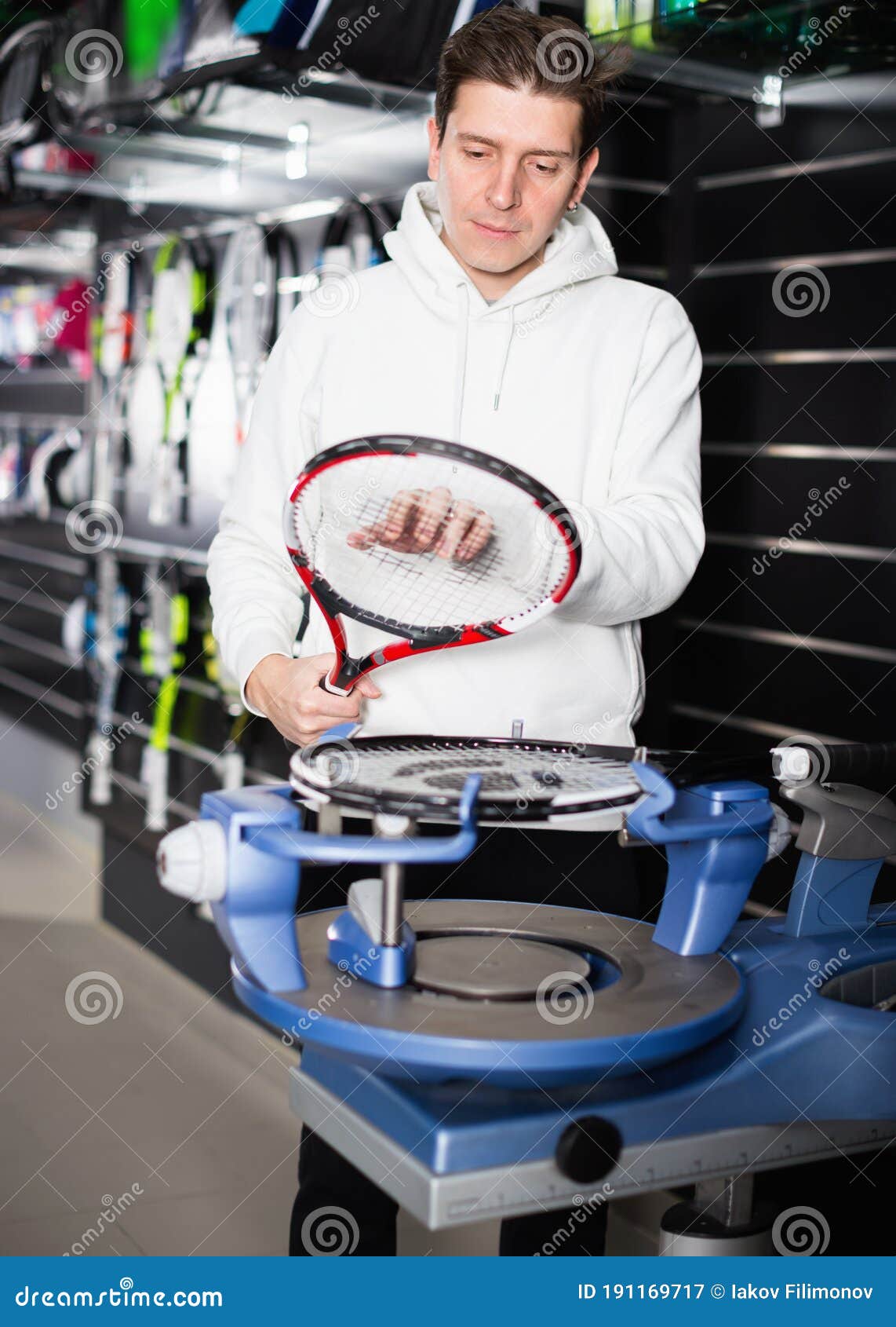 Male Master is Pulling Racket for Tennis in the Store. Stock Image