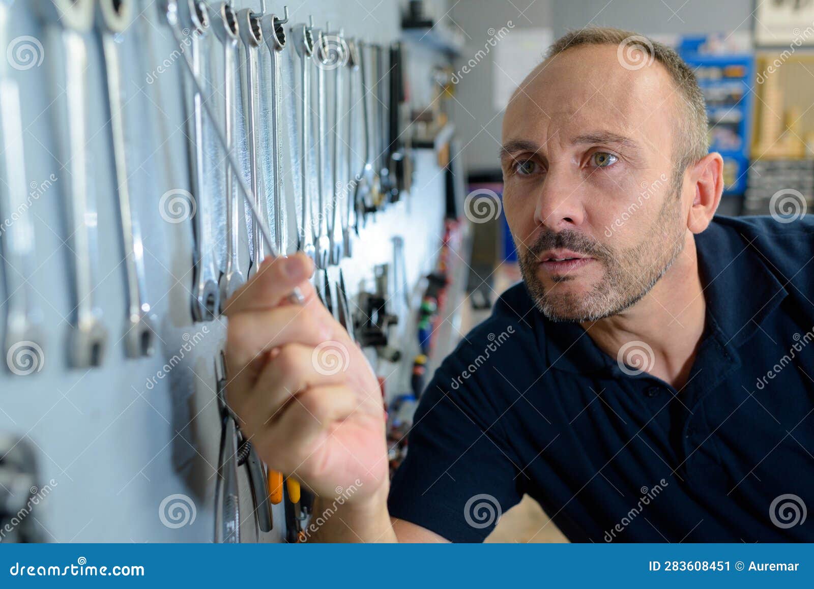 Male Mechanic Choosing Spanner from Rack on Wall Stock Image Image of
