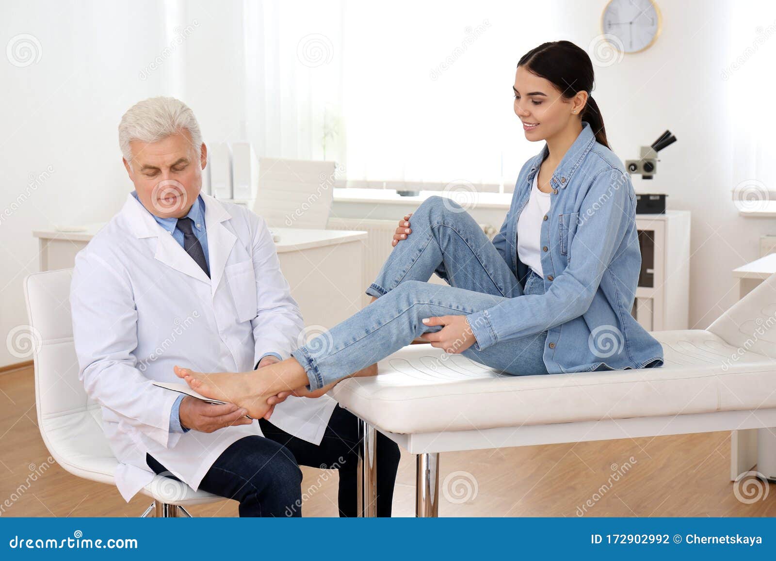 male orthopedist fitting insole on patient`s foot