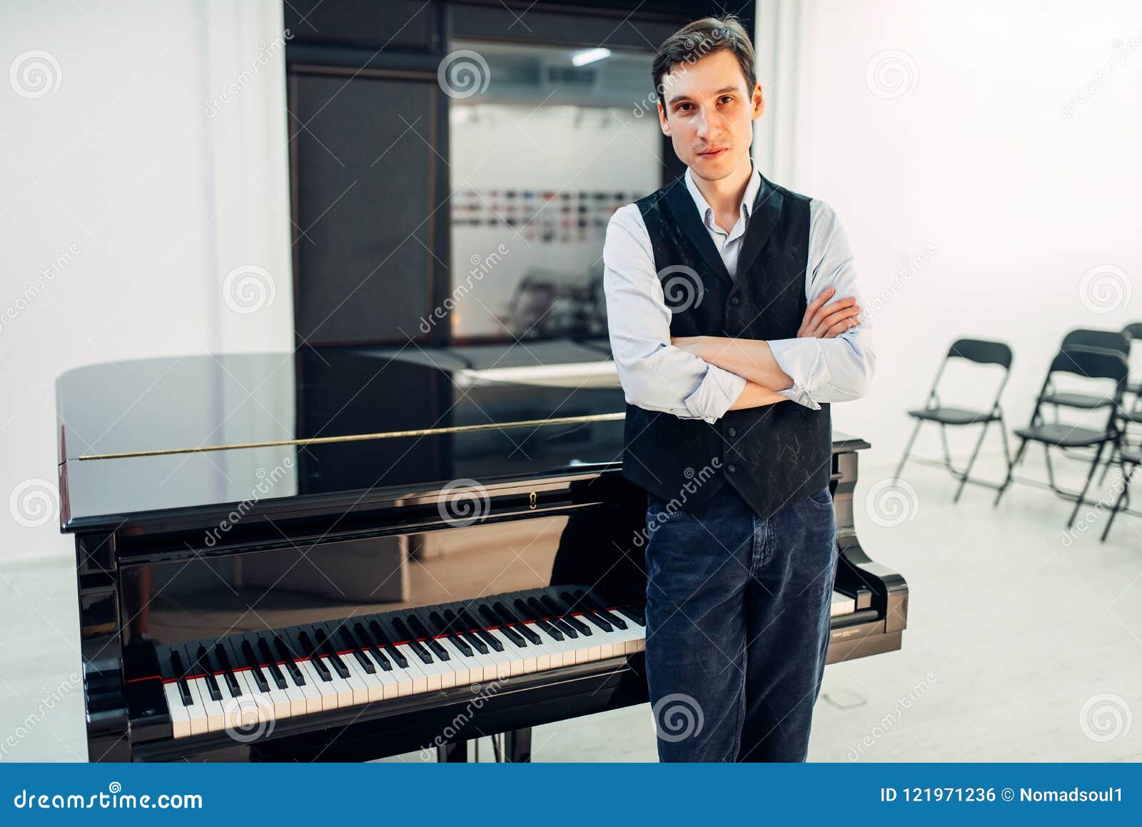 male pianist stands at the black grand piano