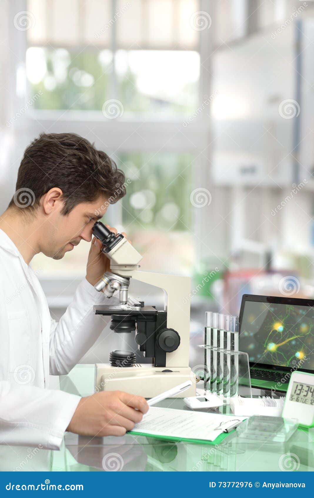 Male Researcher with Microscope in Modern Research Facility Stock Photo