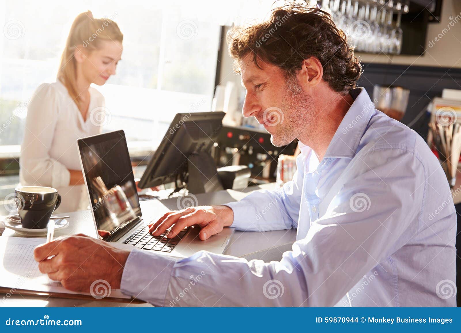 male restaurant manager working on laptop