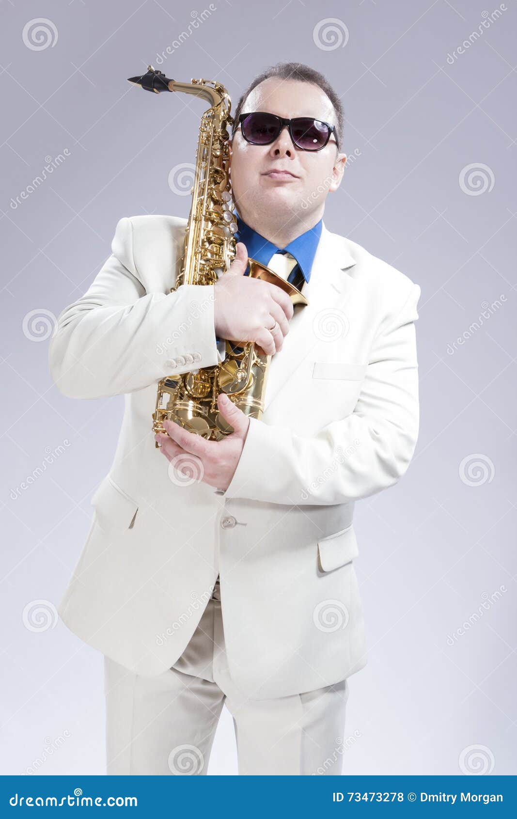 Male Saxophone Player Posing with Alto Saxo in White Suit and