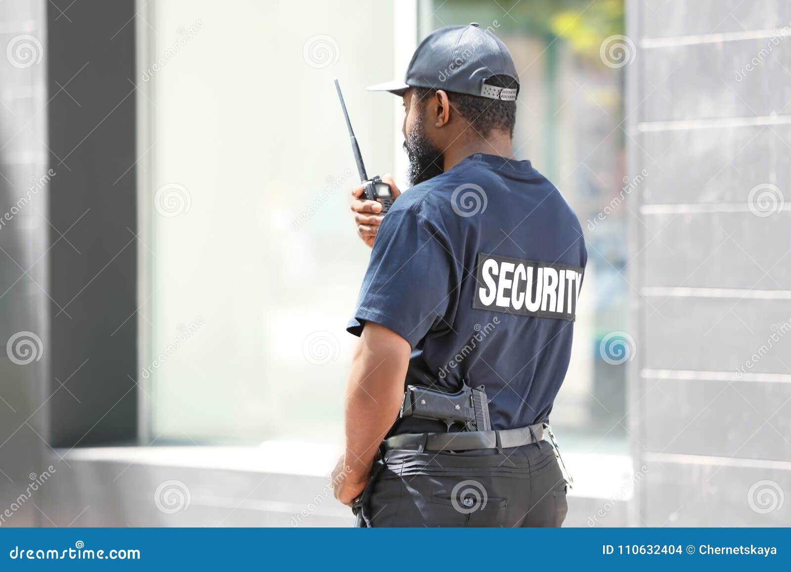 Male Security Guard Using Portable Radio Transmitter Stock Photo