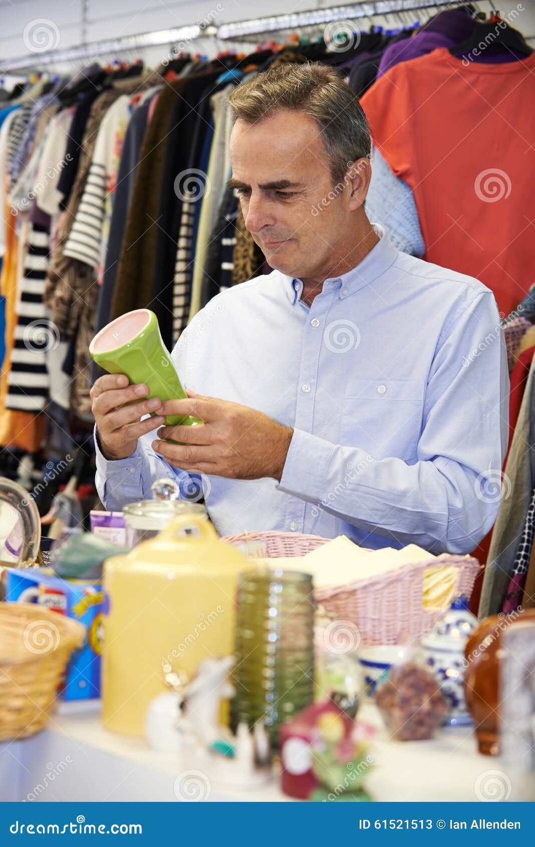 male shopper in thrift store looking at ornaments