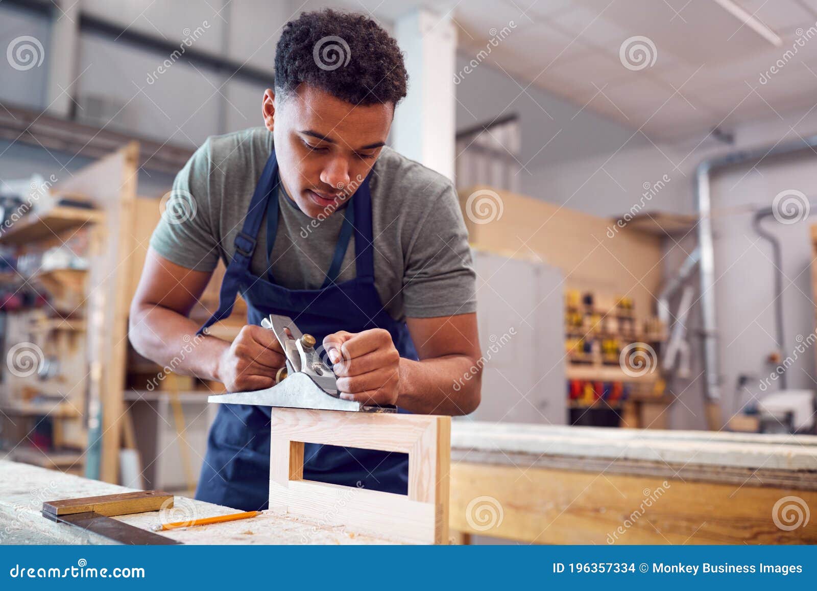 Male Student Studying for Carpentry Apprenticeship at College Using