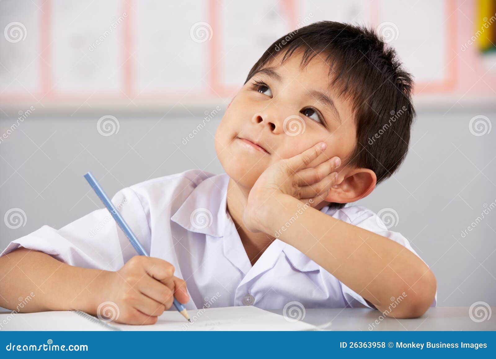 male student working at desk in chinese school