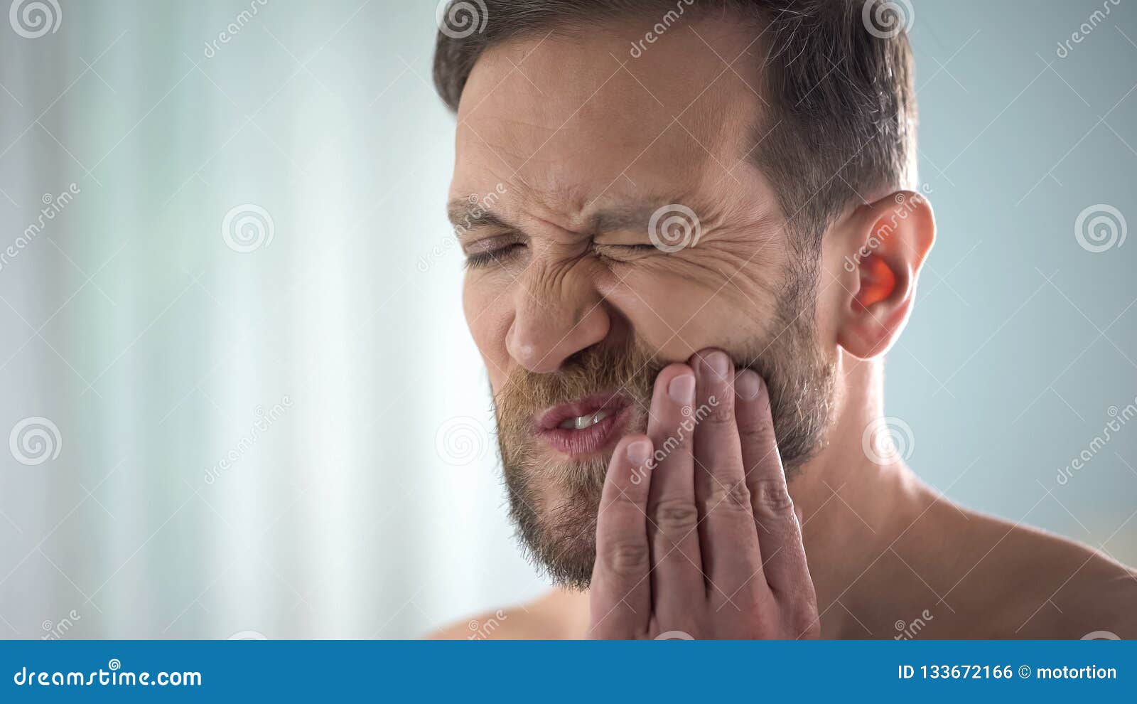 Male suffering from tooth ache, strong dental pain, pulp inflammation, decay, stock photo