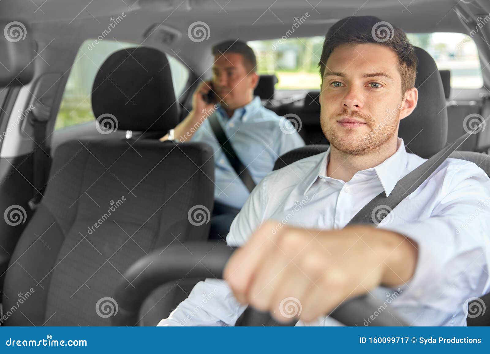 male taxi driver driving car with passenger