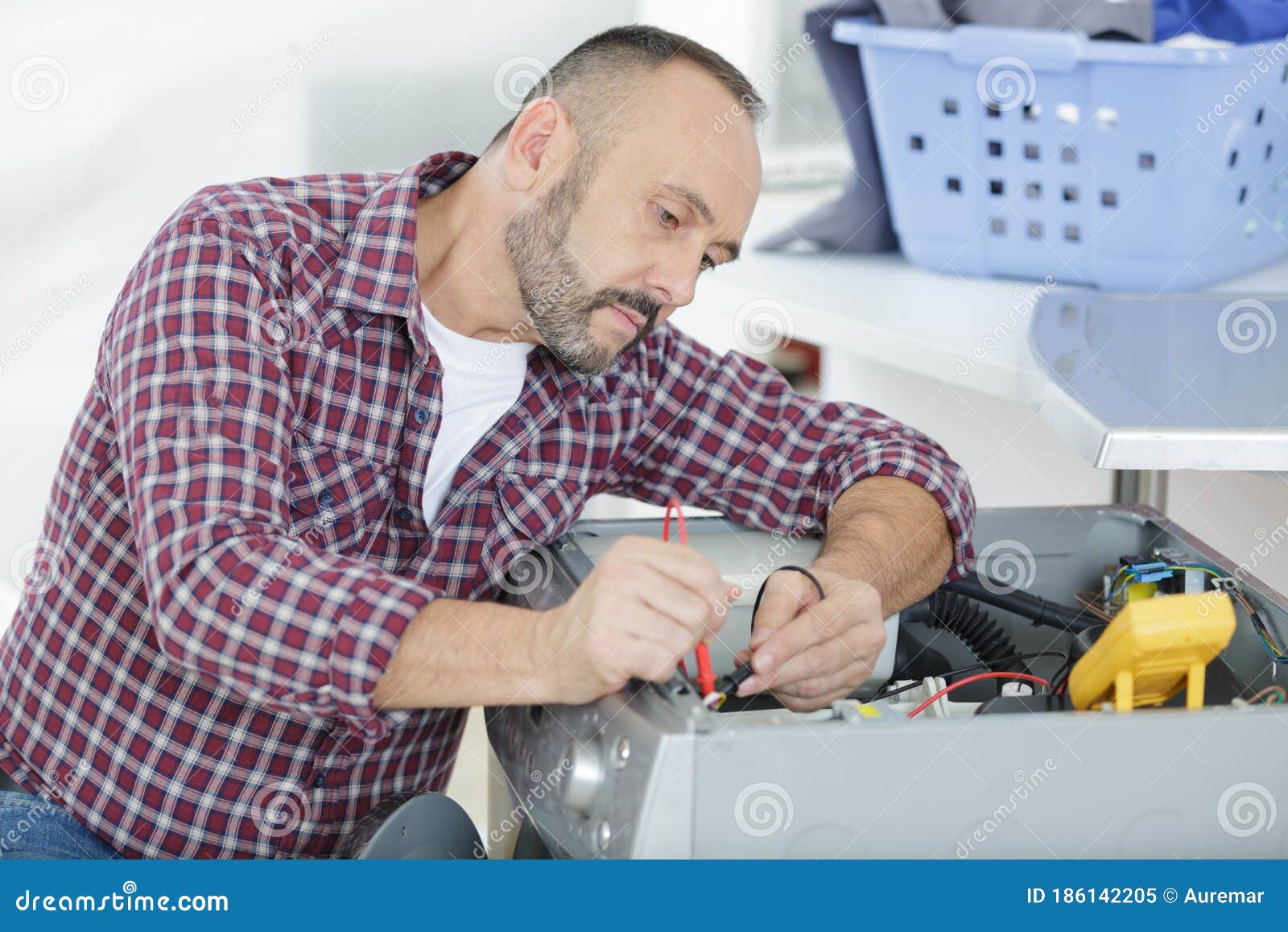 Male Technician Inspecting and Fixing Washer and Dryer Stock Image