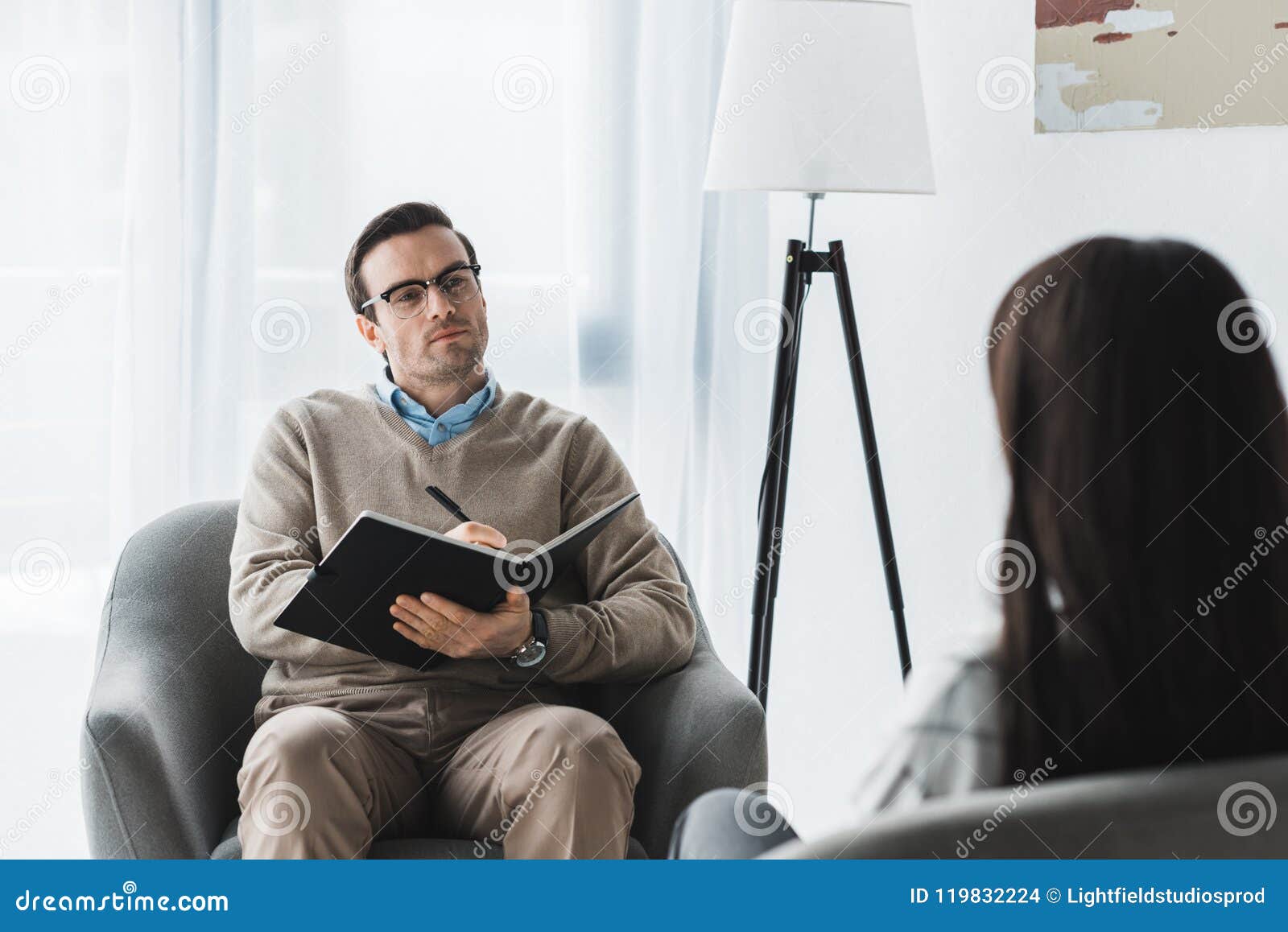 Male Therapist In Glasses Listening To Female Patient Stock Photo