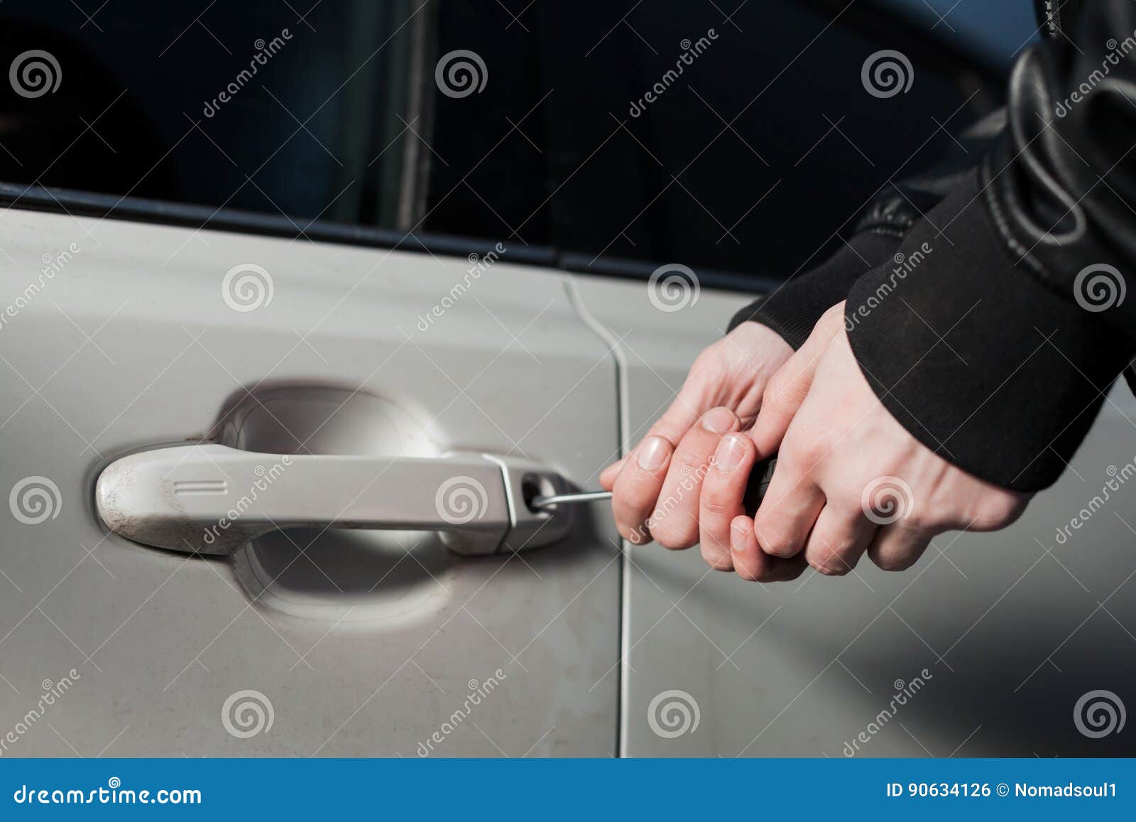 Male Thief Hands Open Car Door With Screwdriver Stock Photo